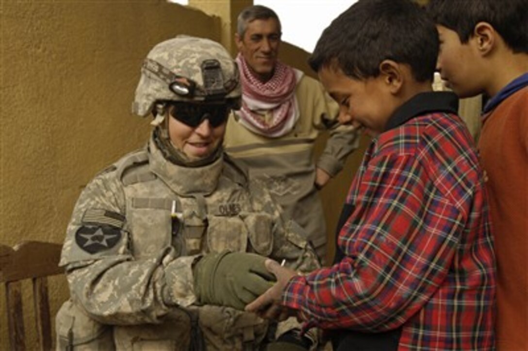 U.S. Army Cpl. Marvin Olnes hands out candy to some Iraqi children during a patrol in Hakeem, Iraq, on Jan. 20, 2008.  Olnes is attached to Foxtrot Company, 52nd Infantry Regiment, 4th Stryker Brigade Combat Team, 2nd Infantry Division.  