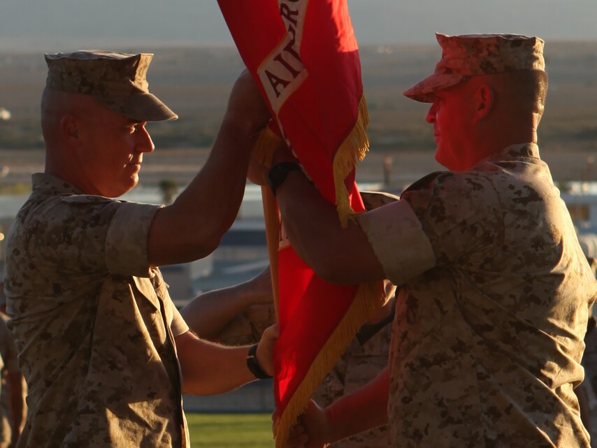 Brig. Gen. H. Stacy Clardy (left), the new commanding general of the of the Combat Center and Marine Air Ground Task Force Training Command, recieves the Marine Corps Flag from Maj. Gen. Charles M. Gurganus, the former commanding general, during a change of command ceremony at Lance Cpl. Torrey L. Gray Field here Sept. 24.