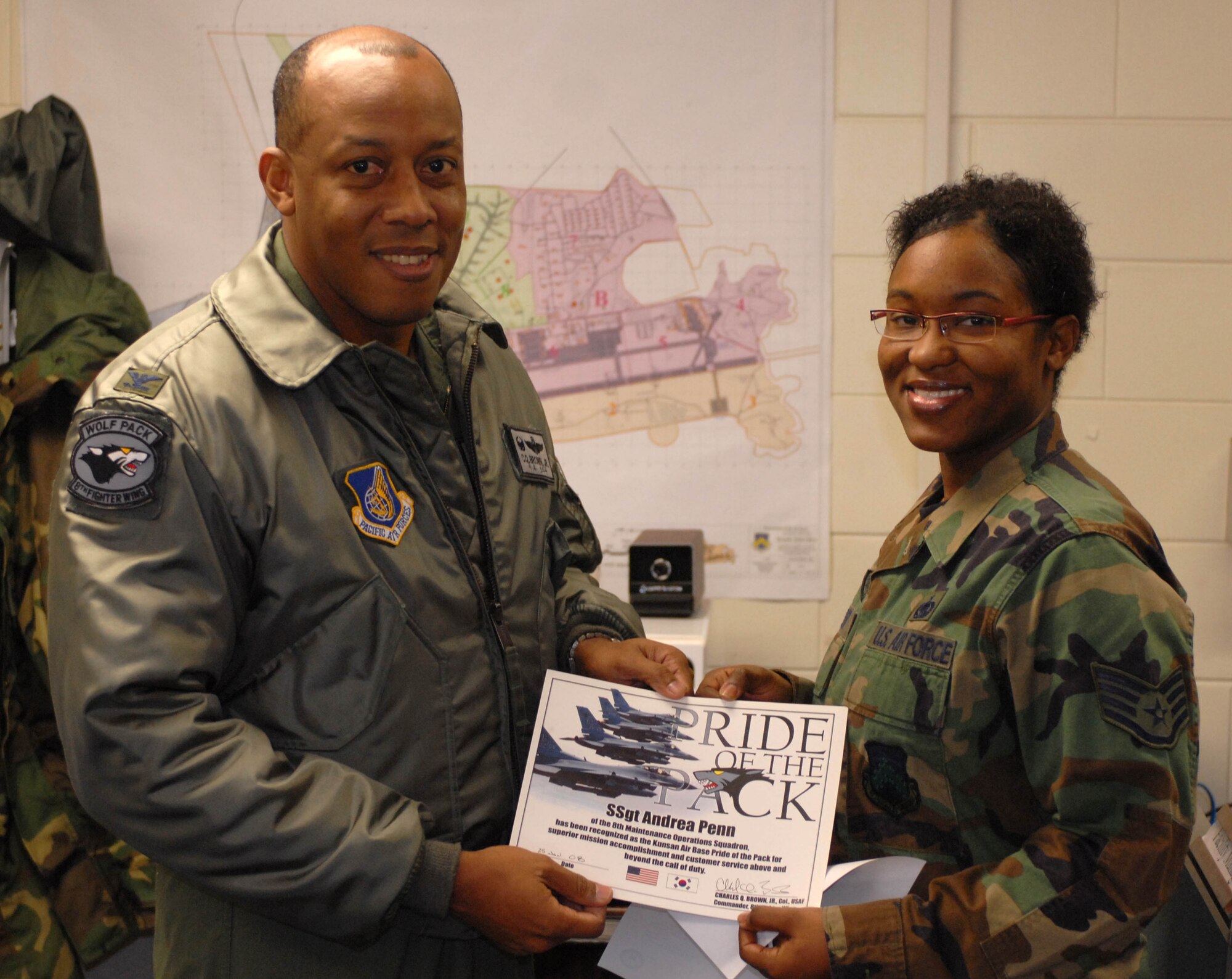 KUNSAN AIR BASE, South Korea -- Colonel CQ "Wolf" Brown, 8th Fighter Wing commander, congratulates Staff Sgt. Andrea Penn, 8th Maintenance Operations Squadron, NCO in charge of exercise and contingency programs here Jan.25. Sergeant Penn was selected as the 8th Fighter Wing's Pride of the Pack for the week of Jan. 20. 