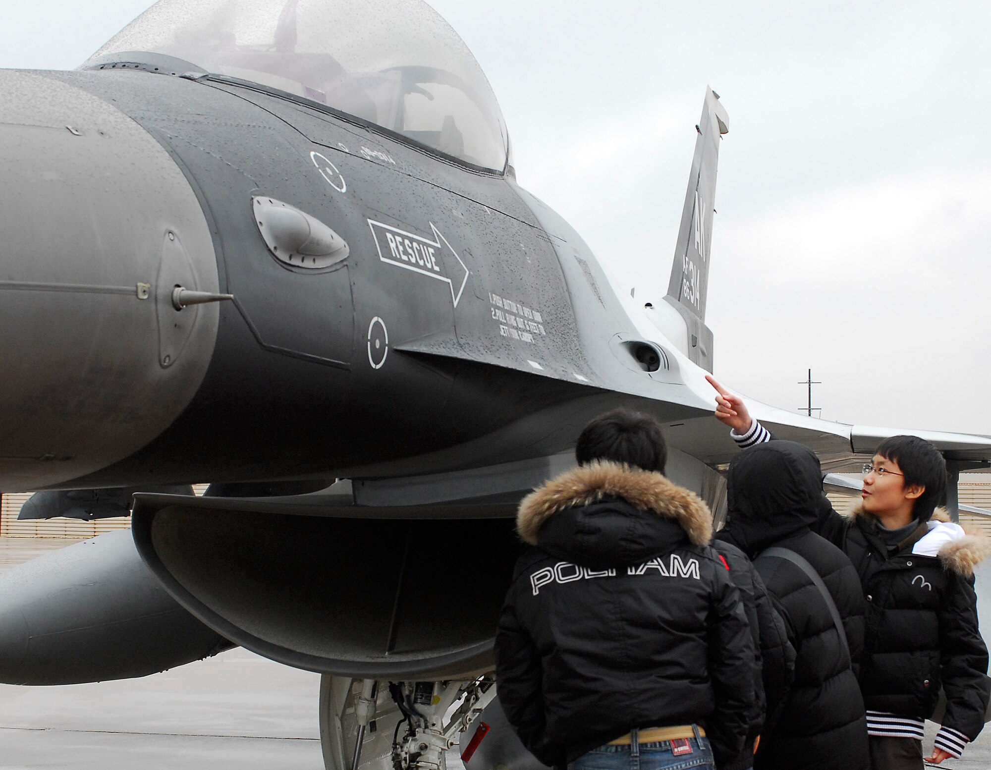 KUNSAN AIR BASE, South Korea -- Korean English camp students take a closer look at an F-16 parked on the flight line during their tour Jan. 23 here. The tour is part of the Good Neighbor Program that aims to enhance the relationship between the local community and Airmen assigned to Kunsan. (U.S. Air Force photo/Senior Airman Giang Nguyen)