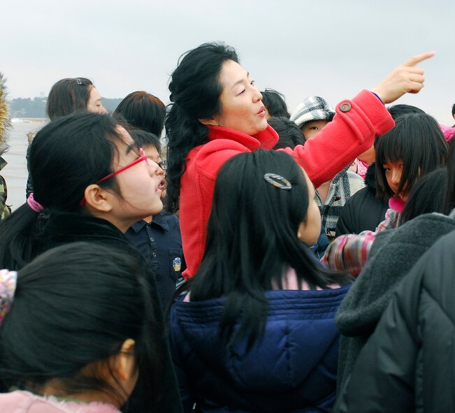 KUNSAN AIR BASE, South Korea -- Mrs. Rosemary Song, 8th Fighter Wing public affairs, guides a tour for Korean English camp students here Jan 23.  The tour is part of the Good Neighbor Program that aims to enhance the relationship between the local community and Airmen assigned to Kunsan. (U.S. Air Force photo/Senior Airman Giang Nguyen)
