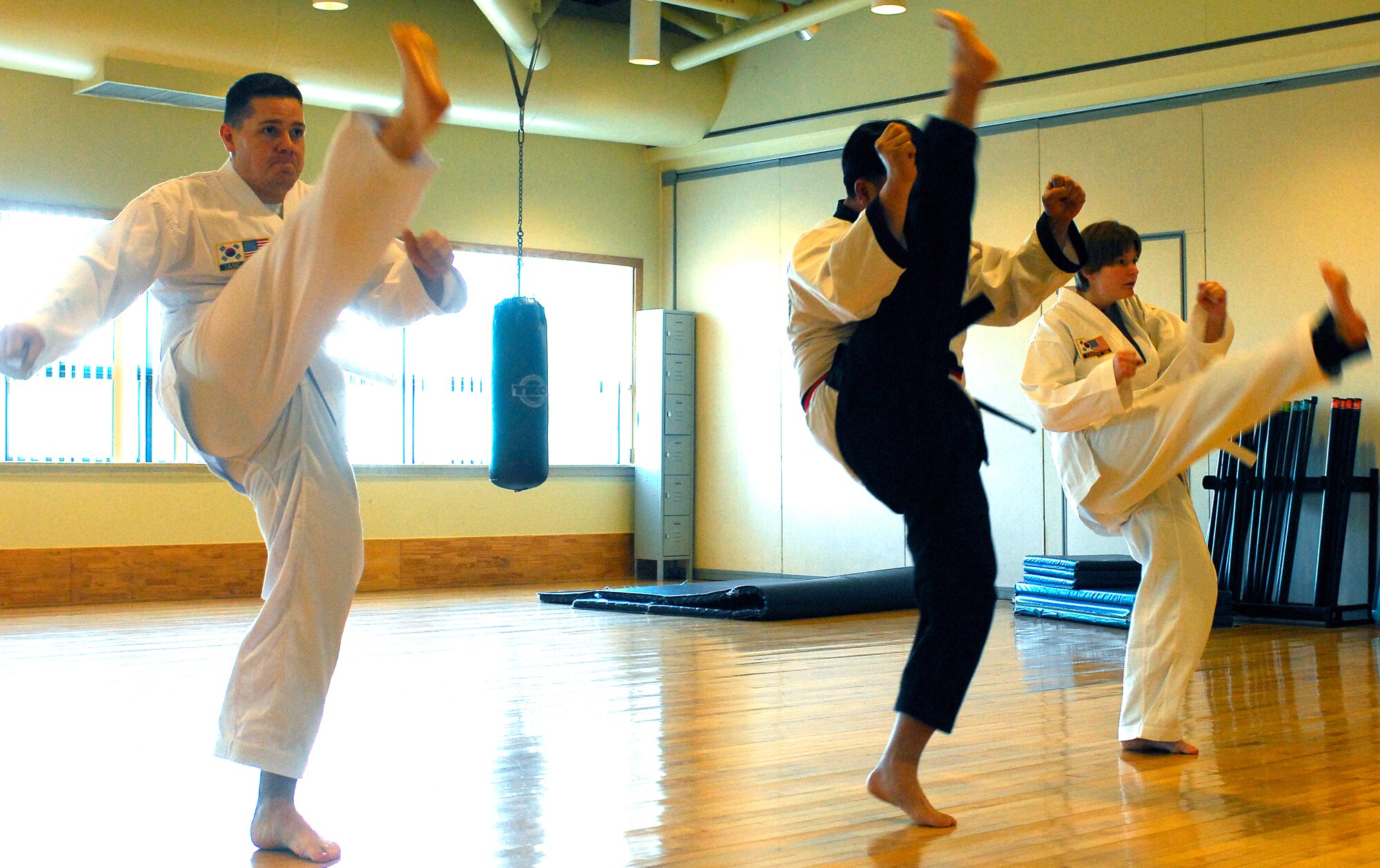 KUNSAN AIR BASE, South Korea -- Master Ch'oe Ki Un, middle, and his students perform Tang Soo Do warm-up techniques Jan. 24 here.  Tang Soo Do class is part of the fit to fight programs designed to improve Airmen's physical well being offered at the base fitness center. (U.S. Air Force photo/Senior Airman Giang Nguyen)
