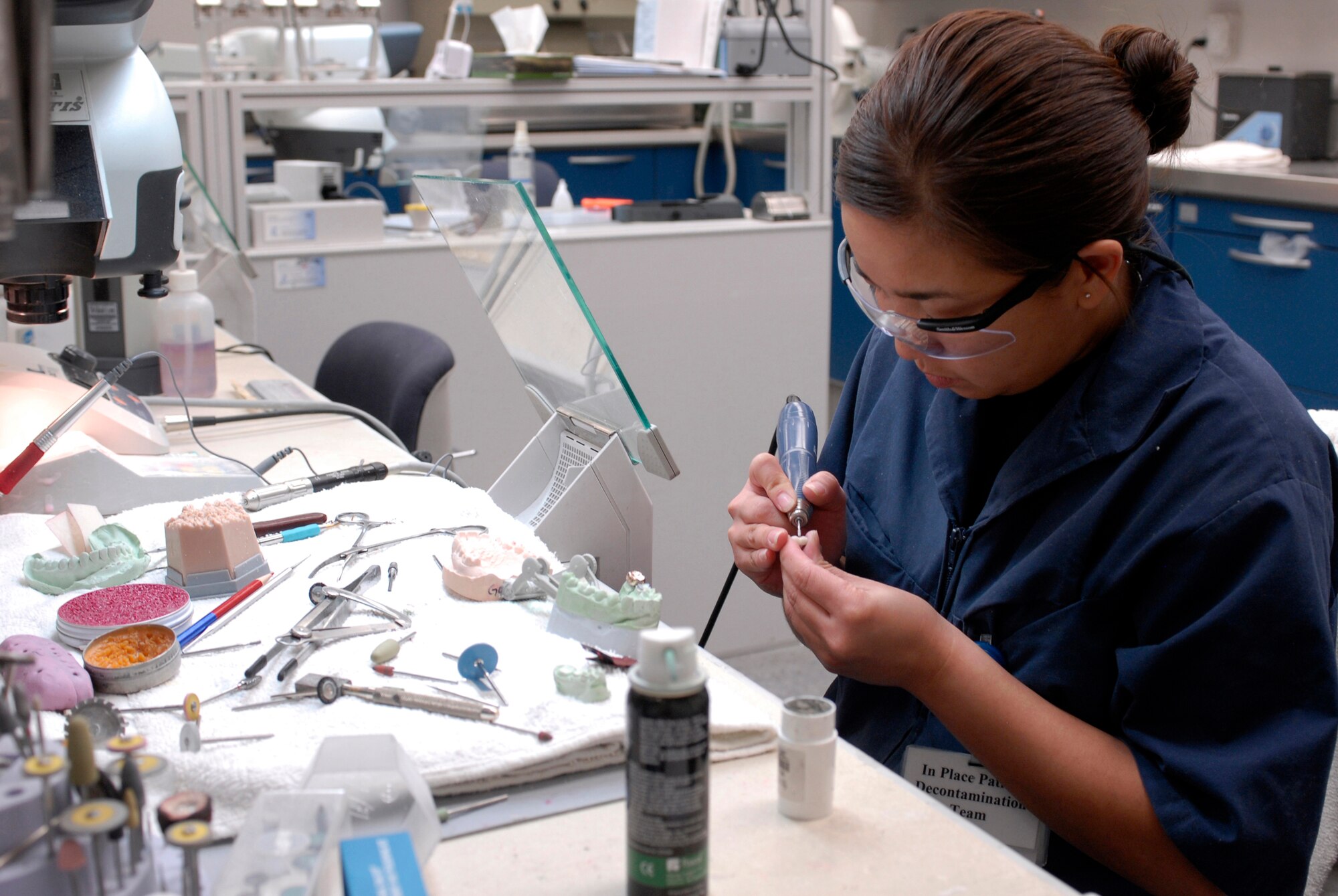 Staff Sgt. Katherine Flores, 56th Dental Squadron laboratory craftsman, finishes a crown. Crowns are used to replace a tooth or cover a tooth after a root canal. (photo by Staff Sgt. Christopher Hummel)
