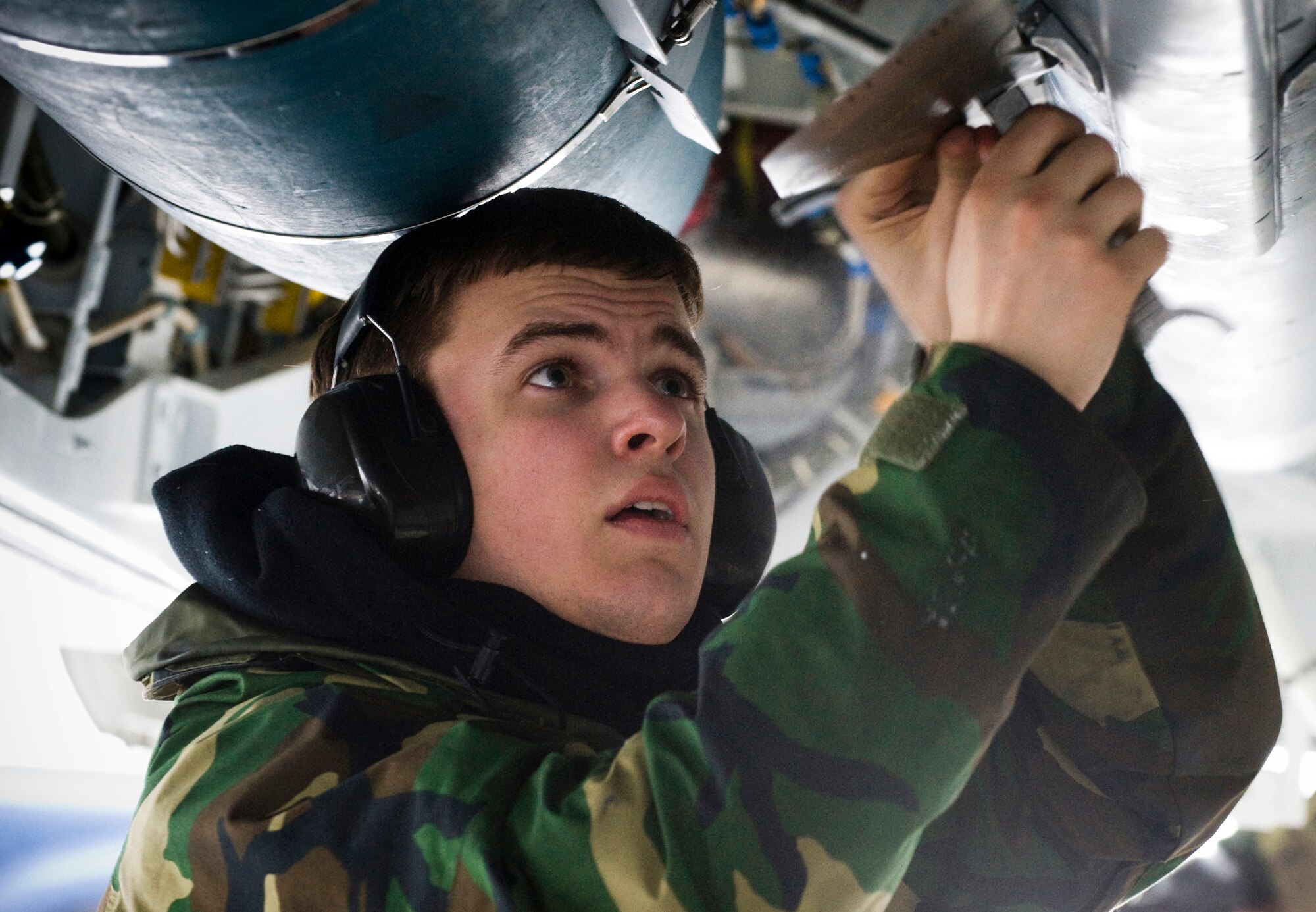 Airman 1st Class Jacob Dean attaches fins to munitions loaded in the F-22A Raptor bomb bays. For the first time at Elmendorf Air Force Base, Alaska, a mock bomb drop over Alaska, Jan. 16, provides integral training for both fighters and maintainers in preparation to declare its initial operation capabilities. Airman Dean is assigned to the 3rd Aircraft Maintenance Squadron, 90th Aircraft Maintenance Unit. (U.S. Air Force photo/Senior Airman Garrett Hothan)