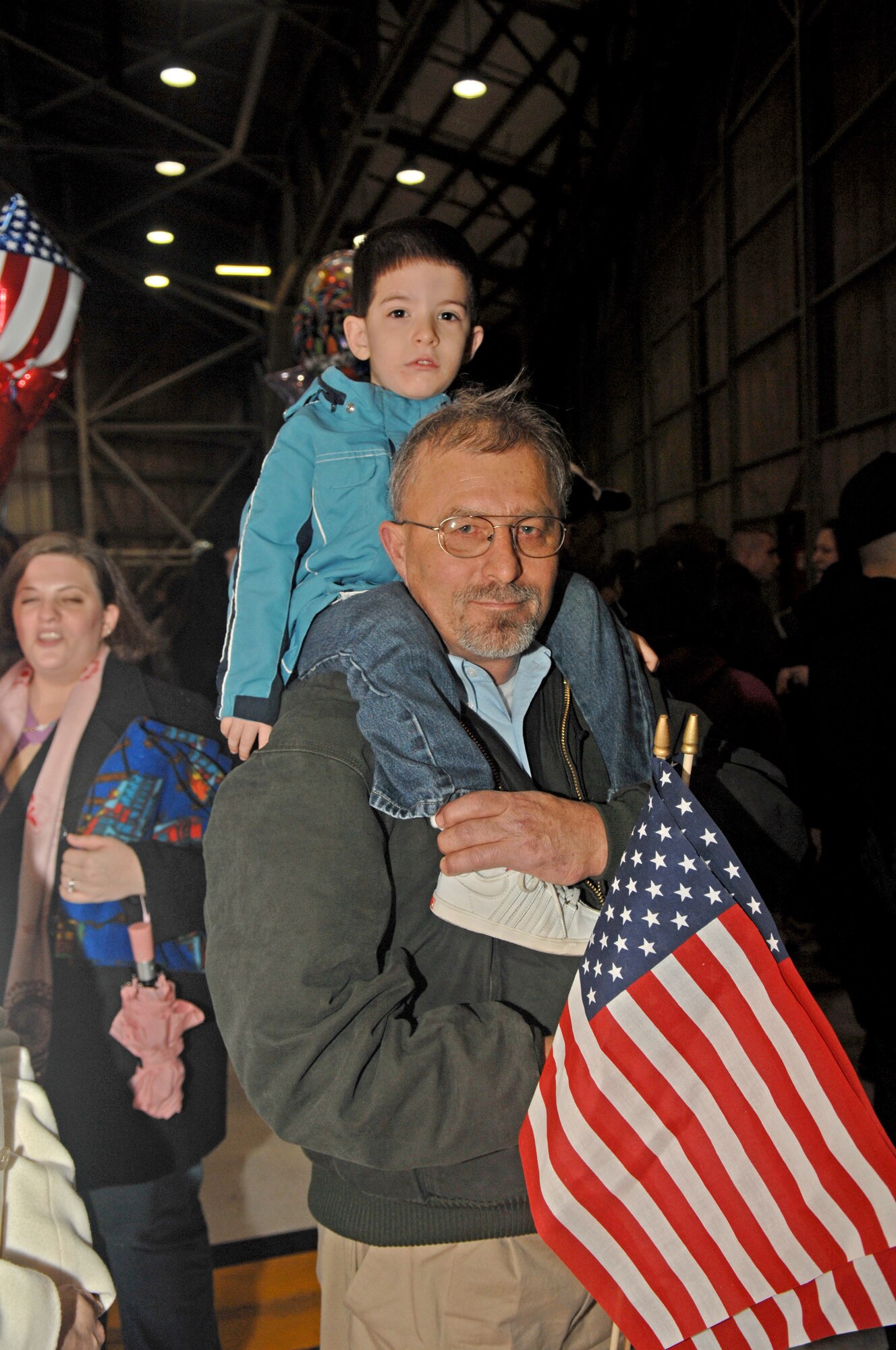 SEYMOUR JOHNSON AIR FORCE BASE, N.C. - Jacob Clark sits on top of his Grandpa Ray's shoulders while waiting for his dad Michael Clark to return from deployment on January 19. Michael Clark is from the 336th Aircraft Maintenance Squadron.(U.S. Air Force photo by Senior Airman Jessica Klingler)