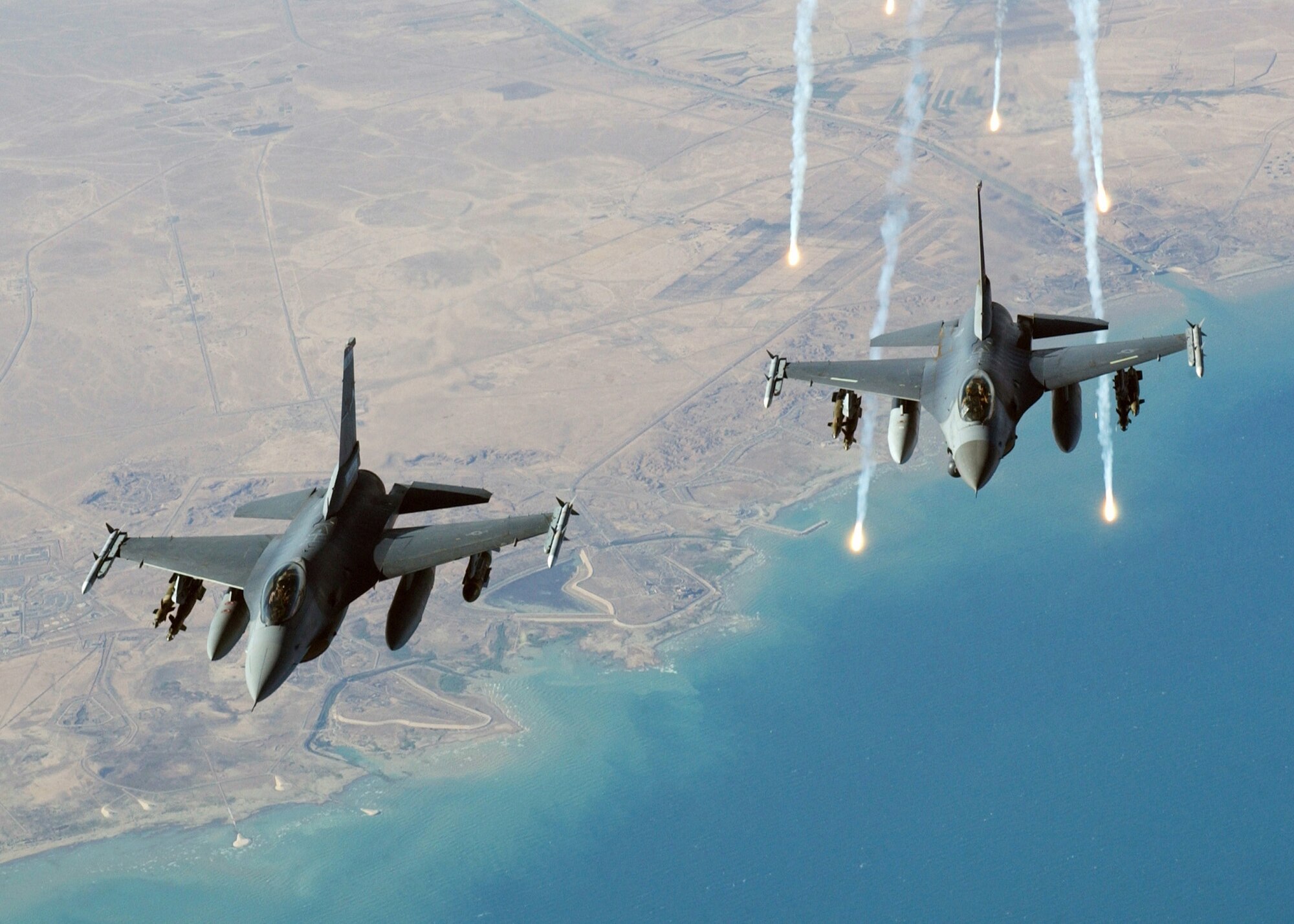 A single US Air Force F-16C Fighting Falcon aircraft from the 332nd Air Expeditionary Wing, Balad AB, Iraq, flying in a two man formation, launches electronic countermeasure flares, following an aerial refueling mission over Iraq, during Operation Iraqi Freedom.  (Air Force photo by Tech. Sgt. Scott Reed)