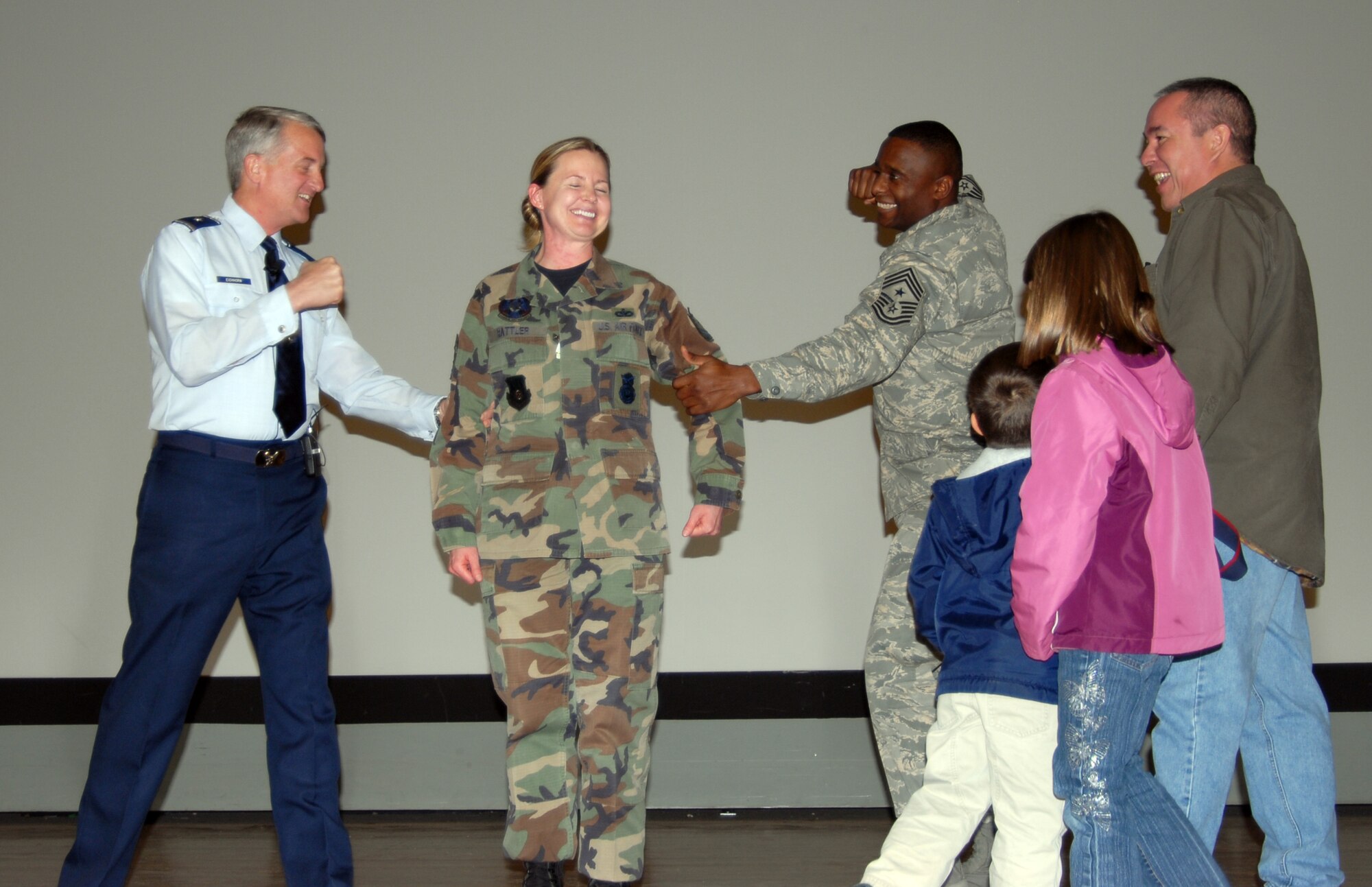 Brig. Gen. David Eichhorn (left), Air Force Flight Test Center commander, and Chief Master Sgt. Juan Lewis (right), 95th Air Base Wing command chief, tack on a new stripe for Tech. Sgt. Kari Rattler, 95th Security Forces Squadron physical security noncommissioned officer, as Sergeant Rattler's family looks on. Sergeant Rattler was promoted to the rank of technical sergeant Jan. 23 through the Stripes to Exceptional Performers program, or STEP. (Photo by Senior Airman Julius Delos Reyes)