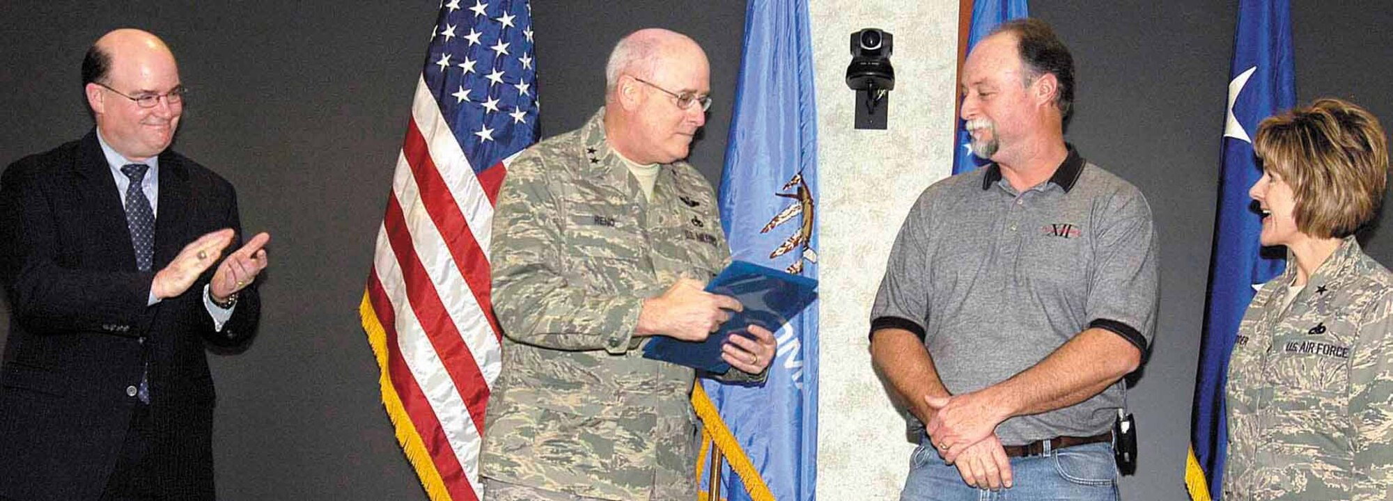 John Allen, deputy director of Flight Standards Service for the Federal Aviation Administration, Washington, D.C., presents an air agency certificate to Maj. Gen. Loren Reno during a ceremony Jan 16 at Tinker.  General Reno, commander of the Oklahoma City Air Logistics Center, accepted the certificate that names the 76th Maintenance Wing as an approved repair station and comes as Tinker assumes work on the first KC-10 being stripped and painted here. Accepting with General Reno are Rick Stuart, 2nd vice president of American Federation of Government Employees, Local 916 and Brig. Gen. Judith Fedder, 76th MXW commander.  (Air Force photo by Margo Wright)