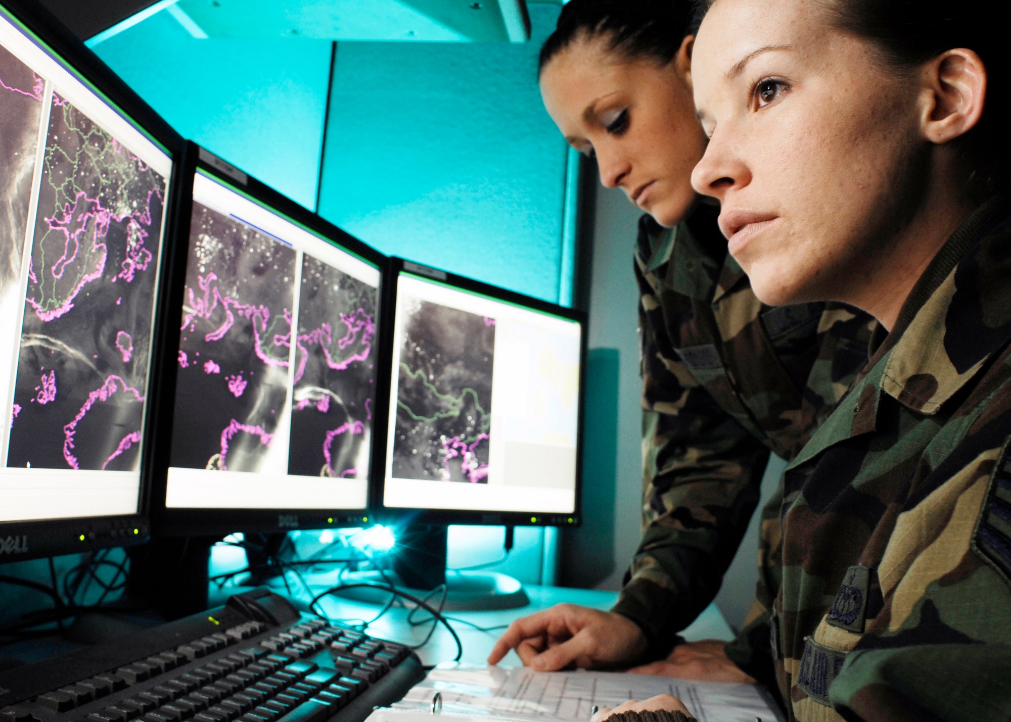 Staff Sgt. Lindsey Flaugher (front), and Senior Airman Cassandra Napolitano-Romero, go over meteorological satellite imagery Jan. 17 at Offutt Air Force Base, Neb. Sergeant Flaugher is from Wilmington, N.C., and Airman Napolitano-Romero is from Lynchburg, Va. Both are meteorological satellite analysts with the 2nd Weather Squadron. (U.S. Air Force photo/G. A. Volb)
