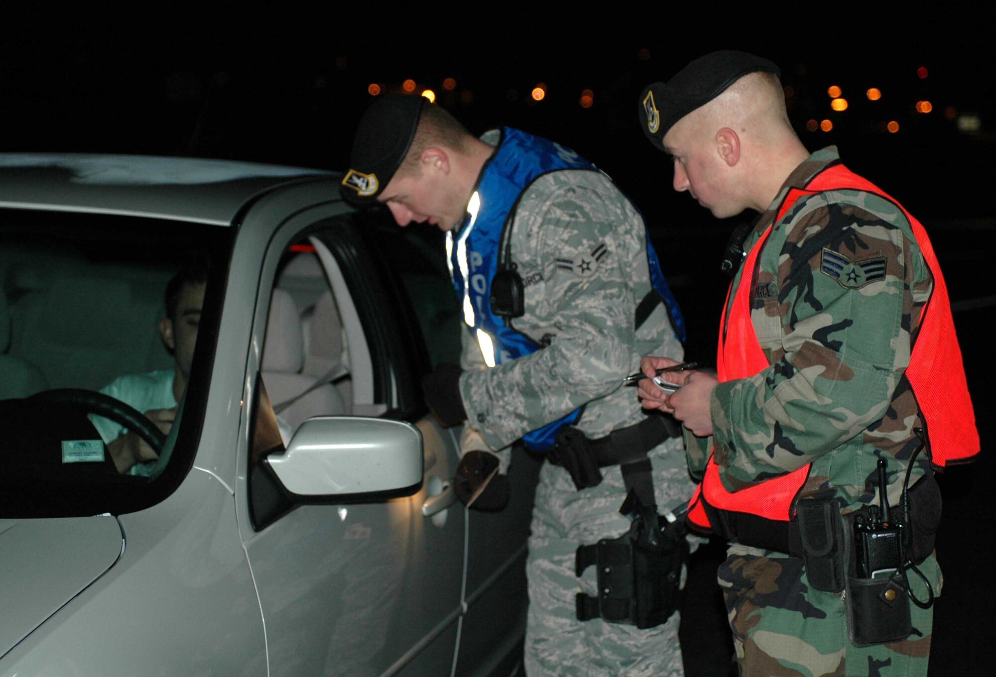 Members of the 60th Security Forces Squadron notify a base patron that all military members must report for a urinalysis test ordered by the base commander during Operation Nighthawk Jan. 19. Operation Nighthawk is a Team Travis leadership program used to provide a Health, Morale and Welfare check with feedback to leadership on the status and activities of members of the installation, their families and visitors to the base. (U.S. Air Force photo/Tech. Sgt. Donald Osborn)