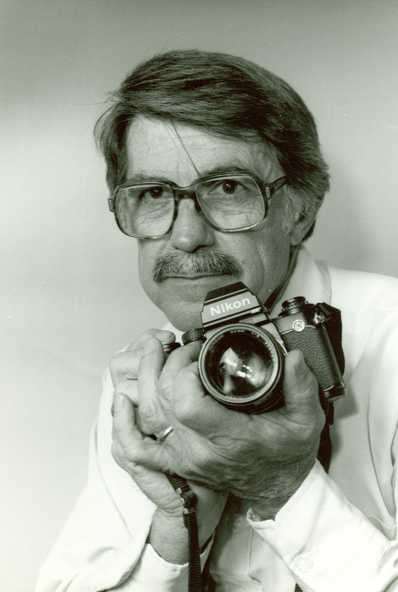 Phil Tarver holds a Nikon F camera in an informal work portrait taken at AEDC in 1987. (Photo provided)