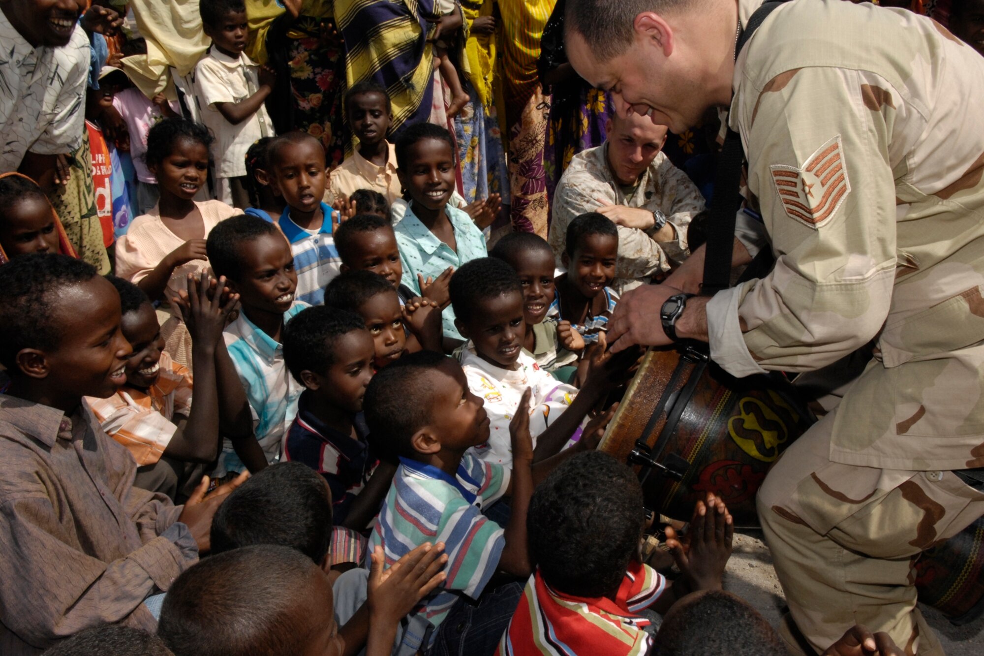 Tech. Sgt. Henrique DeAlmeida, CENTAF Band, Drummer involves the local children while performing for the village of Chebellier, Djibouti in Africa on January 23, 2008. The CENTAF Band "Live Round" will be performing eight shows in 5 days in Africa for the base and the local community. (U.S. Air Force Photo By: Staff Sgt. Christina M. Styer) 

