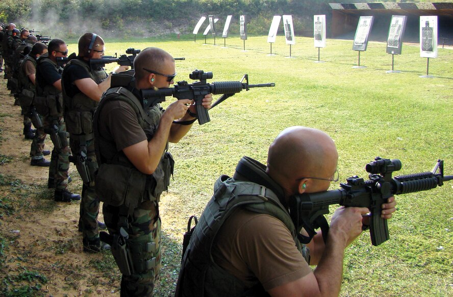 Master Sgt. William J. Stapp (right) and Staff Sgt. James C. Parrish (middle), 919th Security Forces Squadron, practice shooting targets with security forces members from different units during the advanced marksmanship phase of the Deployed Aircraft Ground Response Element program. Members practiced transition drills between two different firearms at the Hurlburt Field firing range. (U.S. Air Force Photo/Tech. Sgt. Chris Dush)