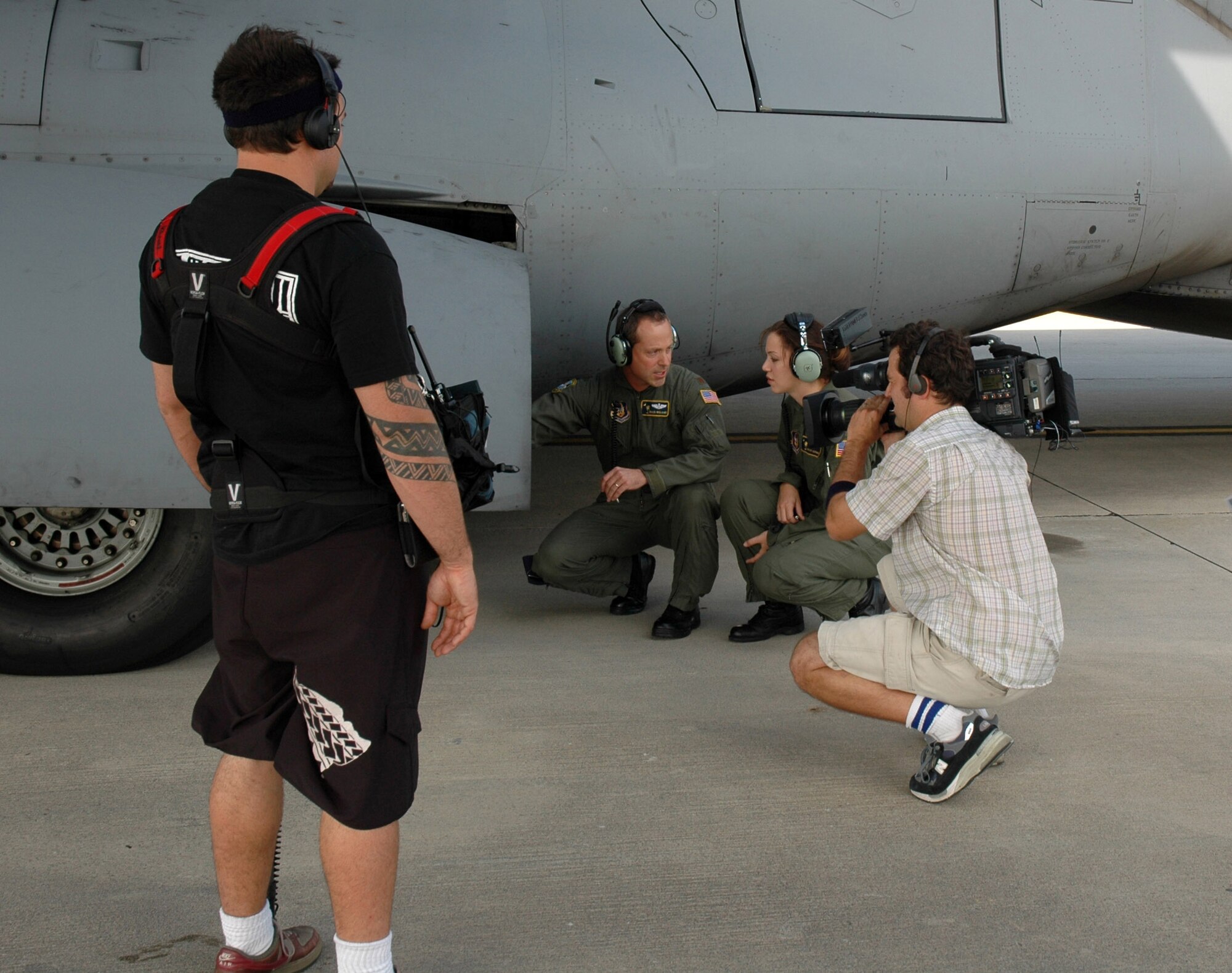 Maj. Trace Williams (left) instructs Capt. Lyndsey Goodman on proper preflight checklist procedures while being filmed by a production crew from the TV show "American Idol" at Charleston Air Force Base, S.C. Captain Goodman was highlighted by the show after her audition. She was one of two military contestants featured on the program this season. Major Williams and Captain Goodman are Reserve pilots with the 317th Airlift Squadron at Charleston AFB. (U.S. Air Force photo/Staff Sgt. Jeff Kelly) 
