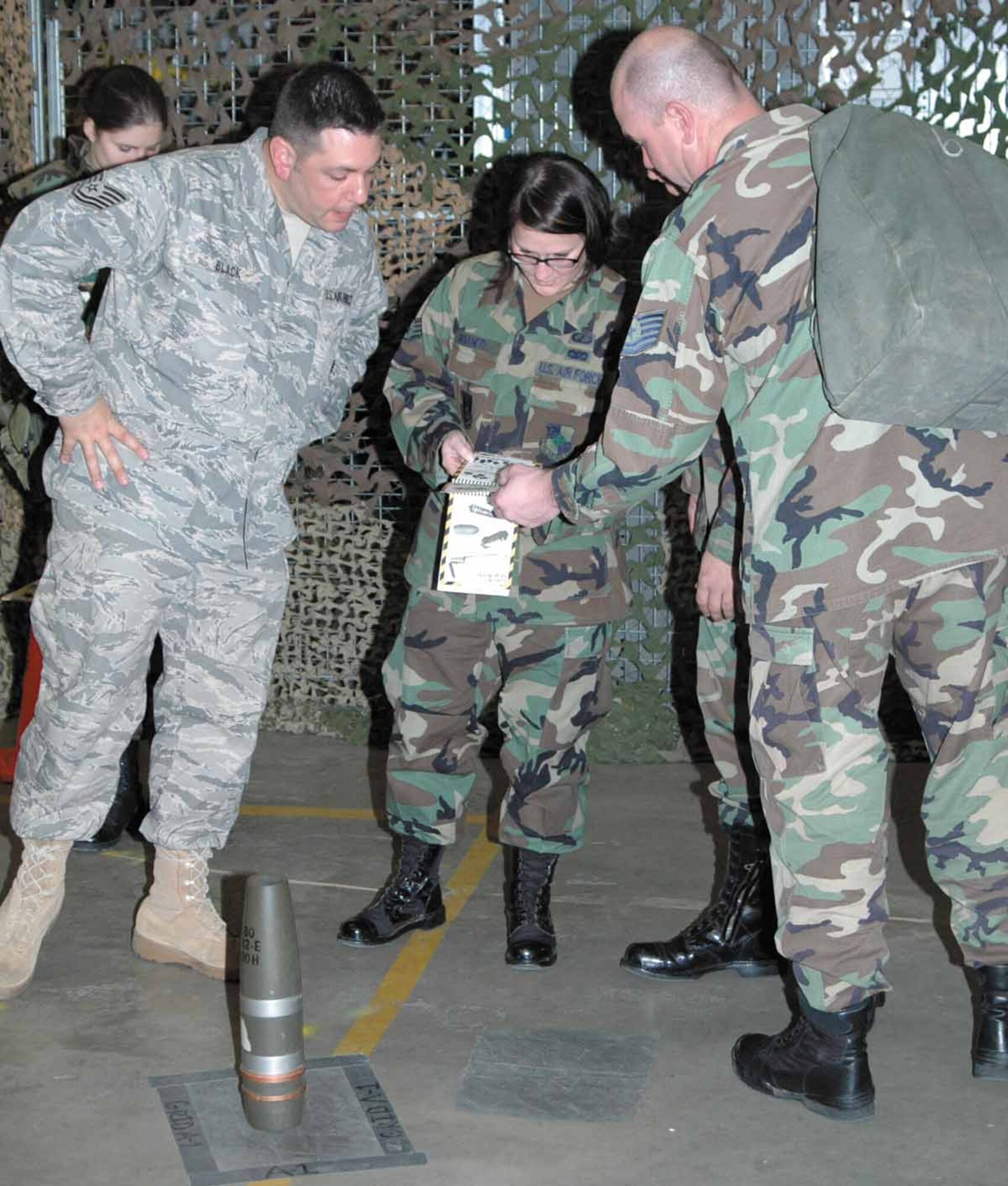 Left to right: 2nd Lieutenant Kerianne Noel, Tech Sgt. Ian Black, Staff Sgt. Casey Shaner and Tech Sgt. Anthony Weiss work together as a team in securing and properly marking a mock dangerous weapon.  (Air Force photo by Danielle Gregory)
