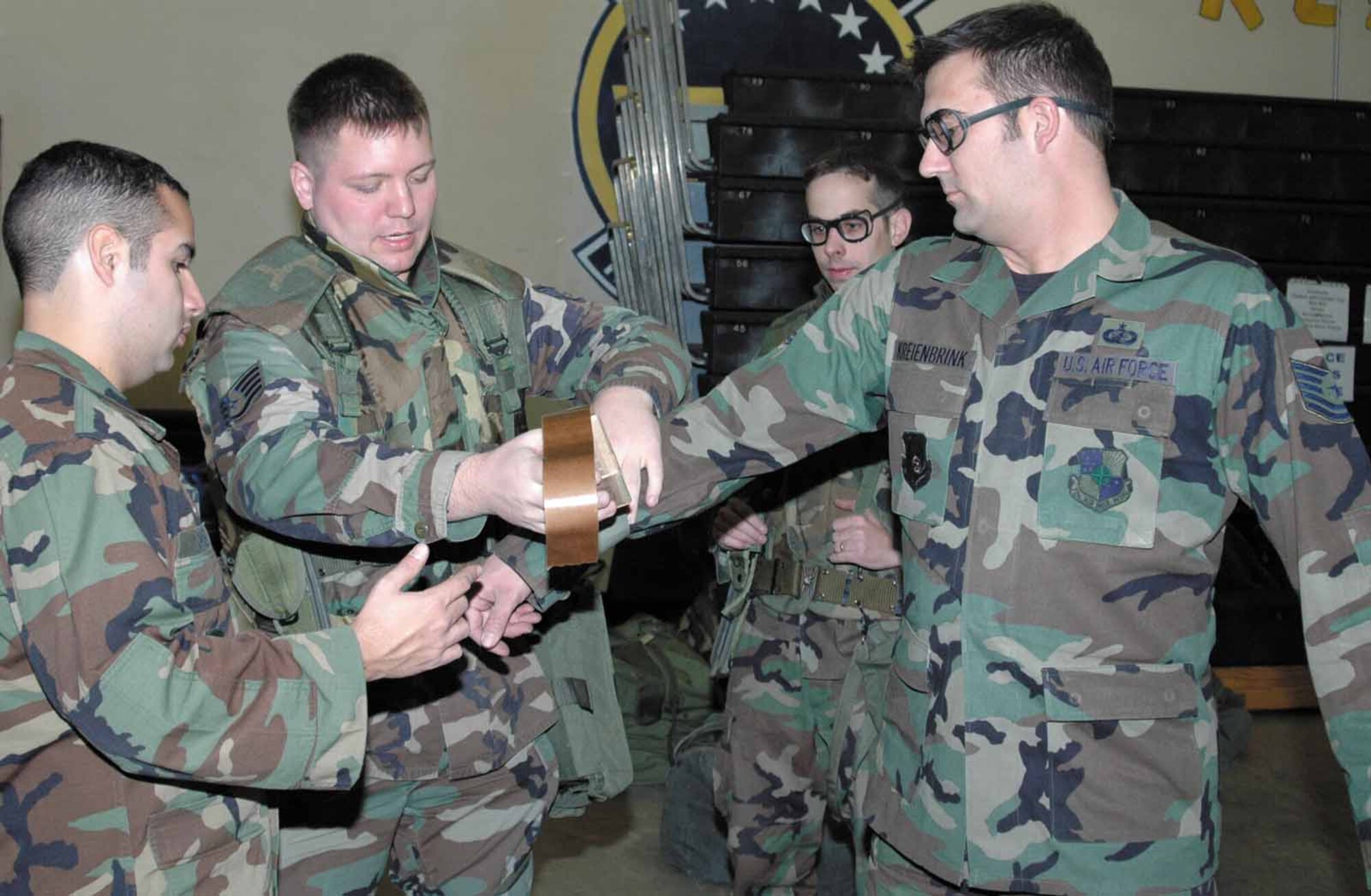 2nd Lieutenant Edward Ortiz, Staff Sgt. Josh High, Staff Sgt. Andre Casiano and Tech. Sgt. Marc Kreienbrink demonstrate the proper way to secure all openings of uniform.  (Air Force photo by Danielle Gregory)