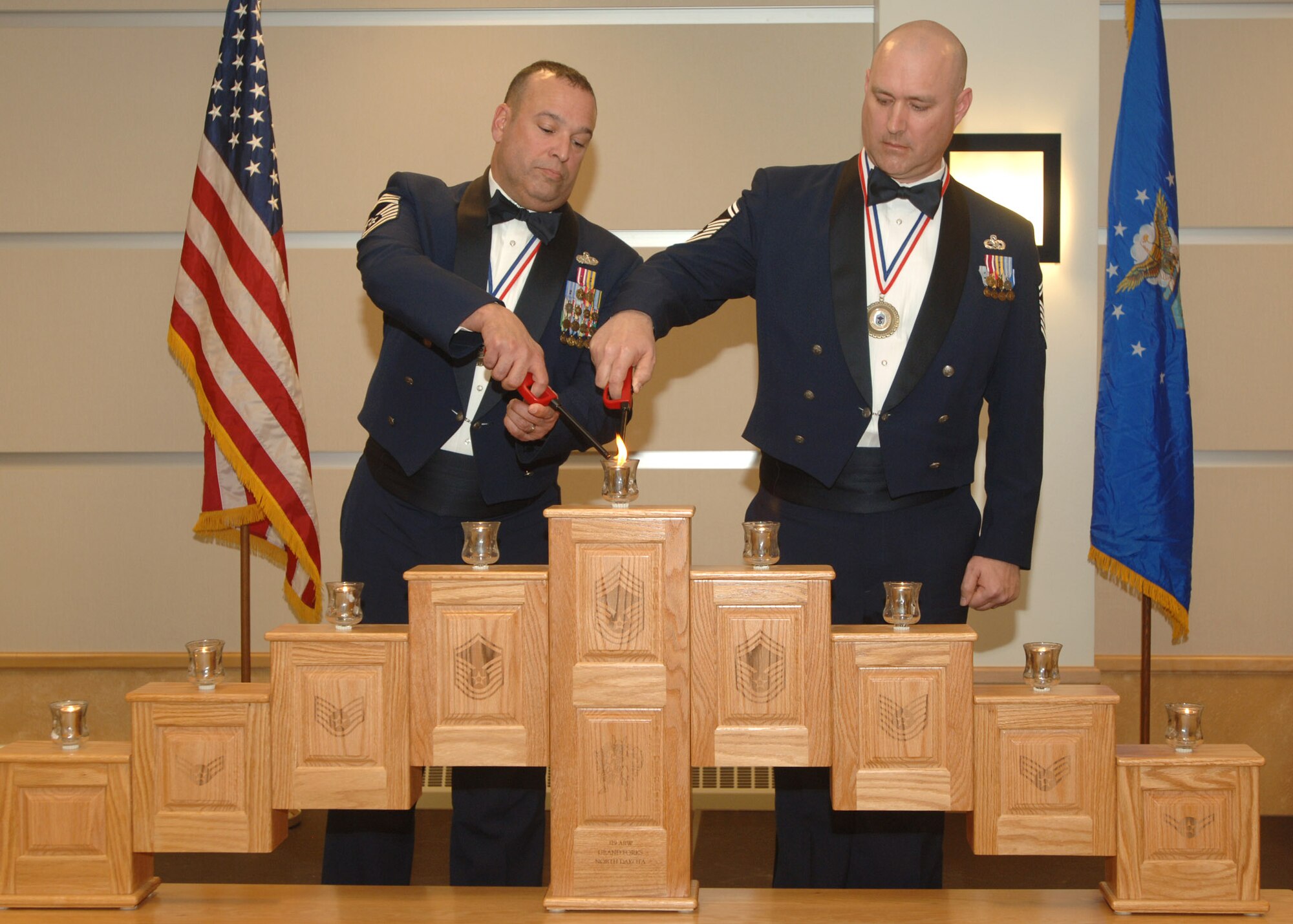 GRAND FORKS AIR FORCE BASE, N.D. - Chief Master Sergeant Maurice Stansbury (left) and Senior Master Sergeant Michael Phillips light the Chief’s candle at the Chiefs Recognition Ceremony here January 18.  The Ceremony is an annual event that honors their promotion to the top one percent of the enlisted ranks, the rank of Chief Master Sergeant.  (Photo/SrA Chad Kellum)