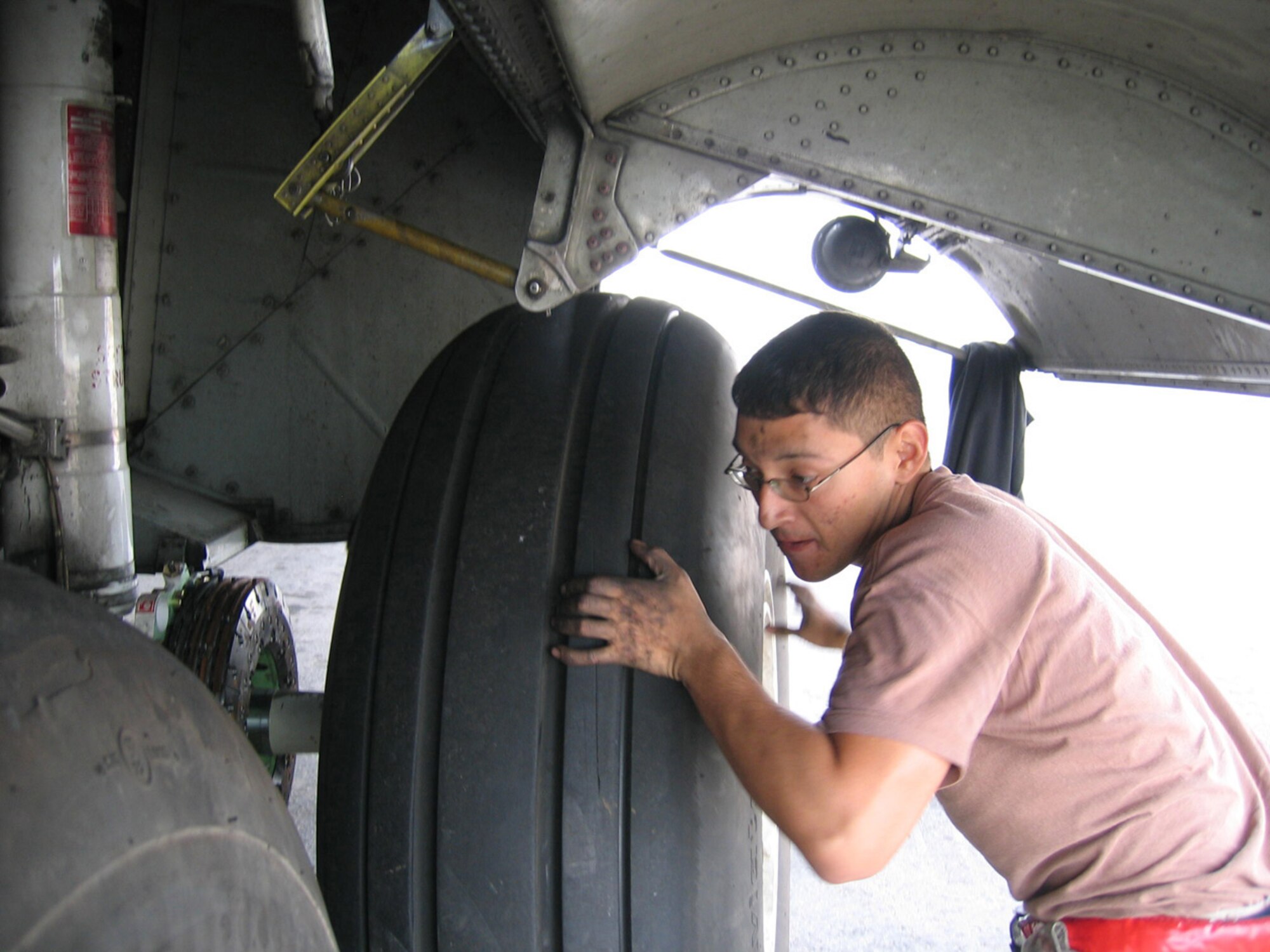 SOUTHWEST ASIA -- Airman 1st Class Anthony Sandoval, 379th Expeditionary Aircraft Maintenance Squadron C-130 crew chief, changes a tire on a Herk at a Southwest Asia air base Jan. 22. Airman Sandoval is deployed from Dyess Air Force Base, Texas. (U.S. Air Force Photo/SrA Carolyn Viss)
