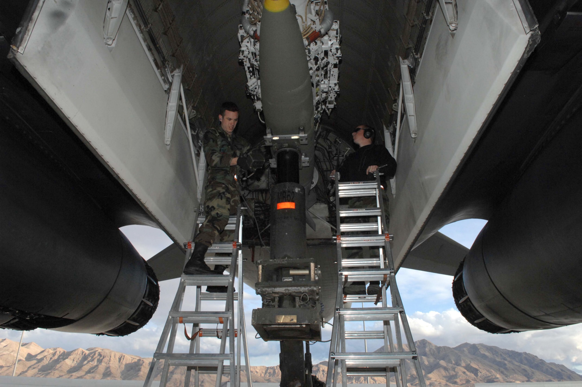NELLIS AIR FORCE BASE, Nev.—Staff Sgts. Marcus Ochoa (left) and Gene Horrigan, weapons team chiefs with the 28th Aircraft Maintenance Squadron, Ellsworth AFB, S.D., prepare to  remove an MK-84 from the munitions bay from a B-1 bomber here Jan. 24. The B-1 bombers, assigned to the 34th Bomb Squadron, Ellsworth AFB, S.D., are flying air interdiction sorties during Red Flag 8-2.1, which is a multi-national exercise training pilots in the world’s most realistic combat scenarios. The experience gained during the exercise is vital to the survival of pilots in combat. (U.S. Air Force photo by Senior Airman Larry E. Reid Jr.)