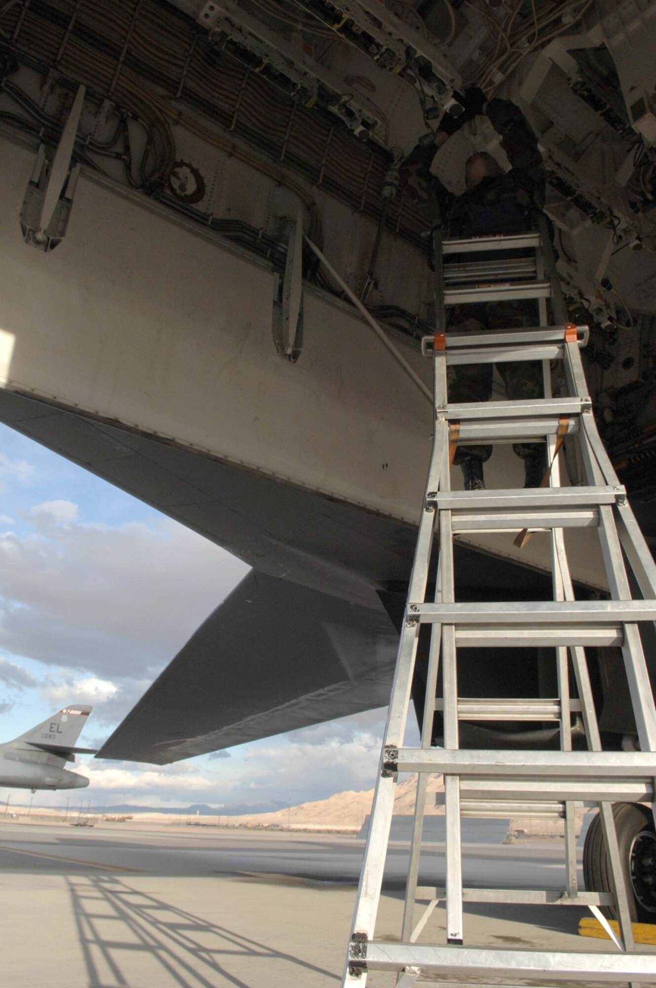NELLIS AIR FORCE BASE, Nev.—Staff Sgt. Marcus Ochoa, a weapons team chief with the 28th Aircraft Maintenance Squadron, Ellsworth AFB, S.D., makes adjustments to the munitions bays on a B-1 bomber here Jan. 24. The B-1 bombers, assigned to the 34th Bomb Squadron, Ellsworth AFB, S.D., are flying air interdiction sorties during Red Flag 8-2.1, which is a multi-national exercise training pilots in the world’s most realistic combat scenarios. The experience gained during the exercise is vital to the survival of pilots in combat. (U.S. Air Force photo by Senior Airman Larry E. Reid Jr.)