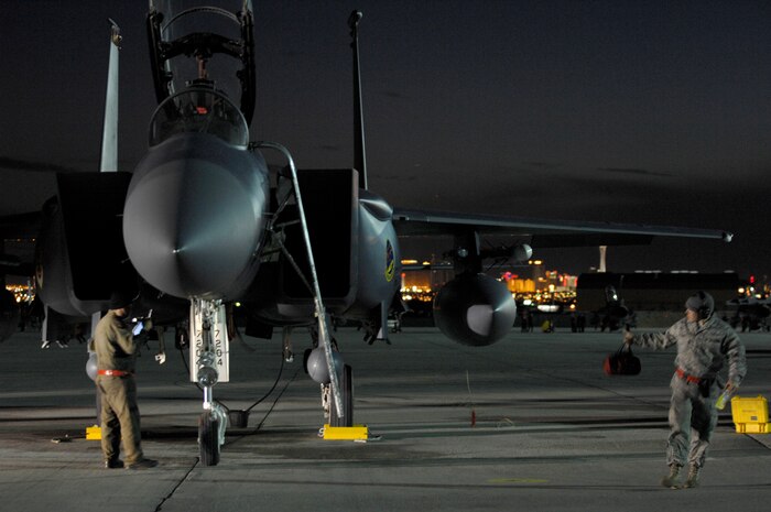 NELLIS AIR FORCE BASE, Nev.—Staff Sgt. Jesse Poynter (left) continues a post-flight inspection on an F-15E Strike Eagle while Airman 1st Class Anthony Prewitt returns to the shop after a mission during Red Flag 8-2.1, here Jan. 23. Sergeant Poynter and Airman Prewitt are both crew chiefs with the 366th Fighter Maintenance Squadron, Mountain Home AFB, Idaho, and are at Nellis with their unit participating in Red Flag, which is a two-week long multi-national exercise training pilots in the world’s most realistic combat scenarios. The experience gained during the exercise is vital to the survival of pilots in combat. (U.S. Air Force photo by Master Sgt. Robert W. Valenca)