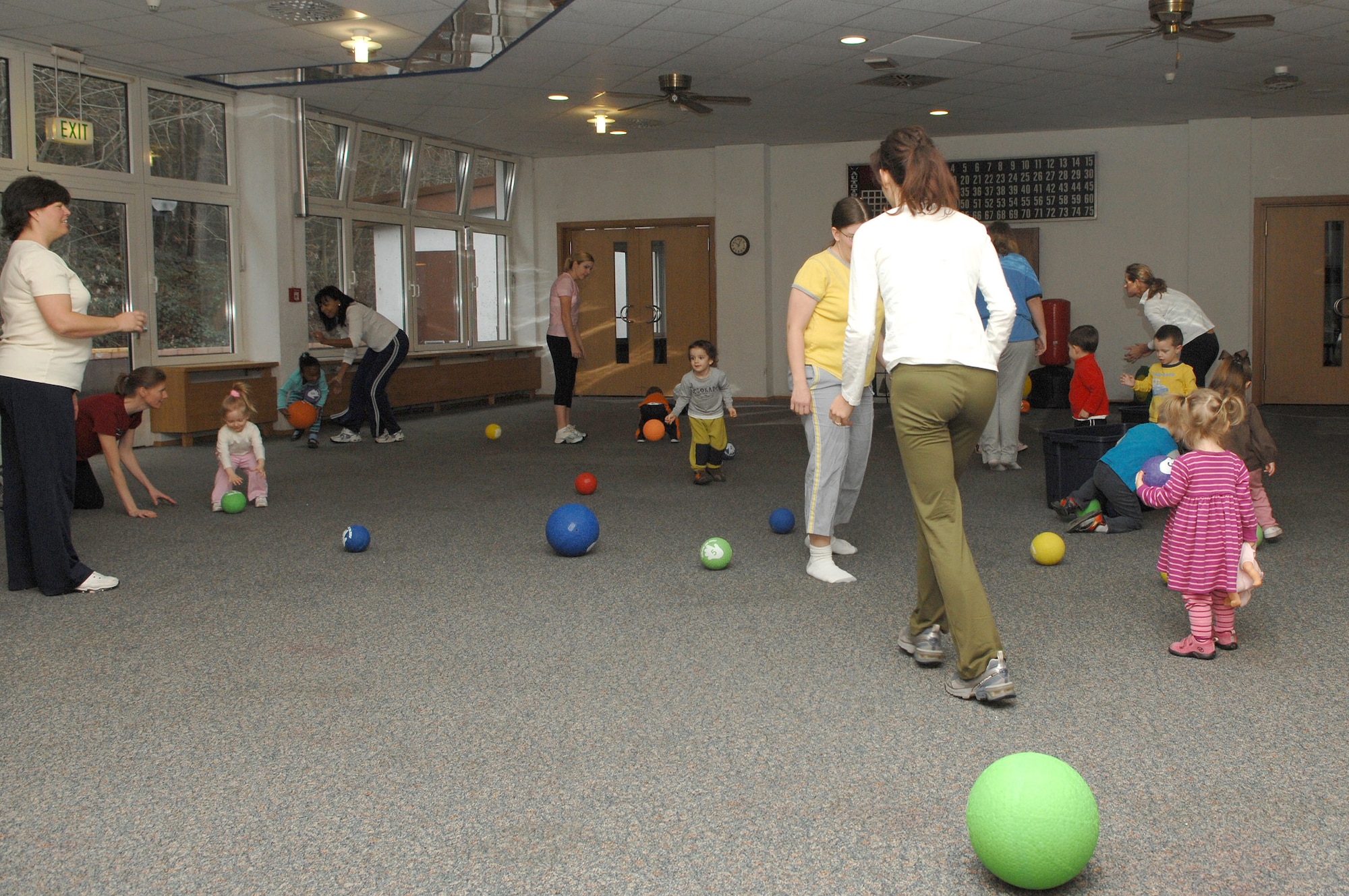 At the beginning of the Mommy and Me Yoga and Fitness class, playground balls are thrown throughout the room as the children hurry to pick them up and place them back in the bins, Jan.18, at the Vogelweh Community Center. This is one of the many activities done to get the children warmed up for the class. (U.S. Air Force photo/Senior Airman Megan M. Carrico)