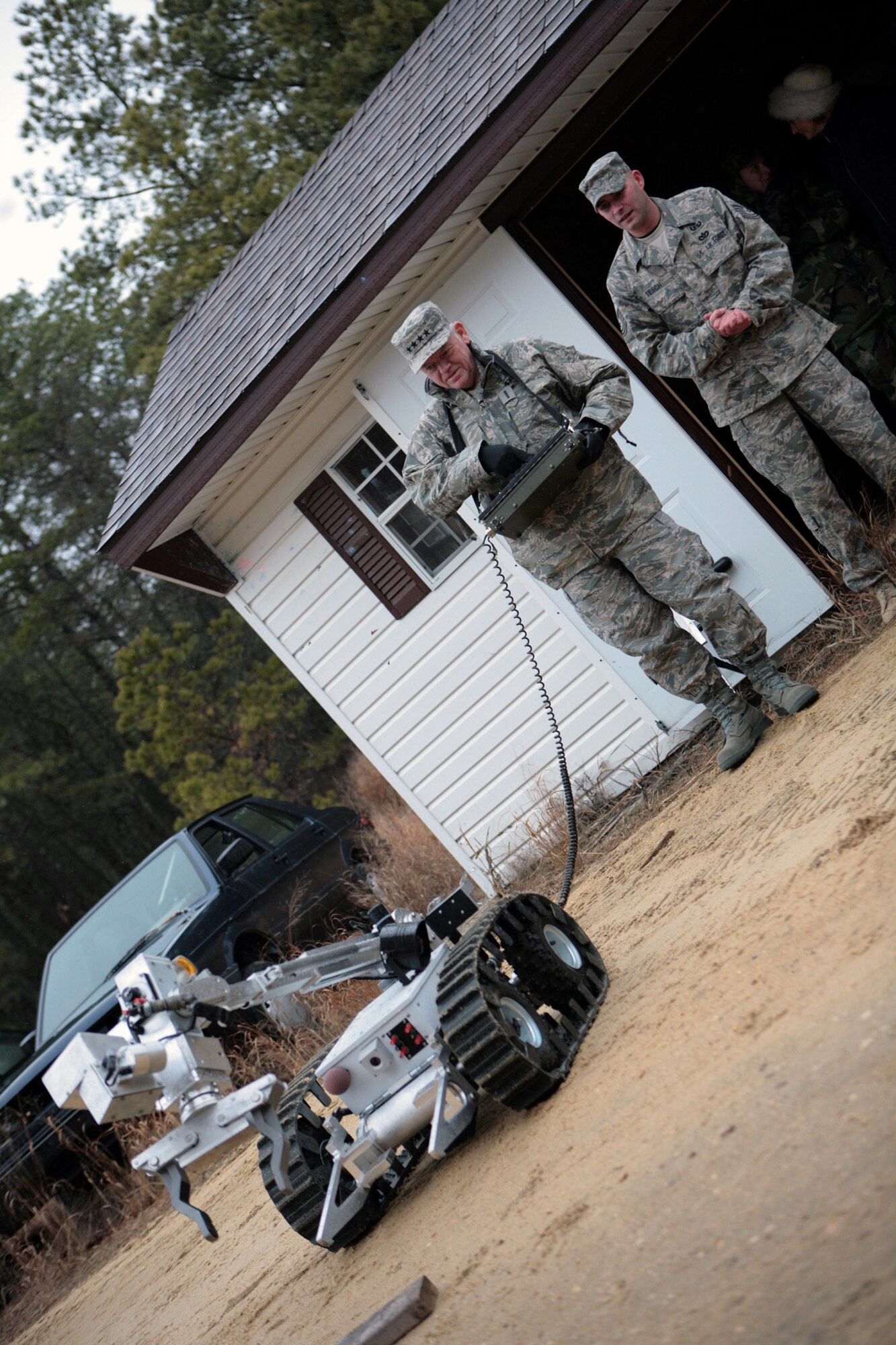 Gen. Arthur Lichte, Air Mobility Command commander from Scott Air Force Base, Ill., practices using a explosive ordnance detection robot while Tech. Sgt. Michael Tesch, U.S. Air Force Expeditionary Center's 421st Combat Training Squadron at Fort Dix, N.J., provides guidance Jan. 22 at Naval Air Engineering Station Lakehurst, N.J.  General Lichte visited the USAF EC at Fort Dix and Air Force Exercise Eagle Flag at Lakehurst as part of his official visit.  (U.S. Air Force Photo/Master Sgt. Bob Lorusso)