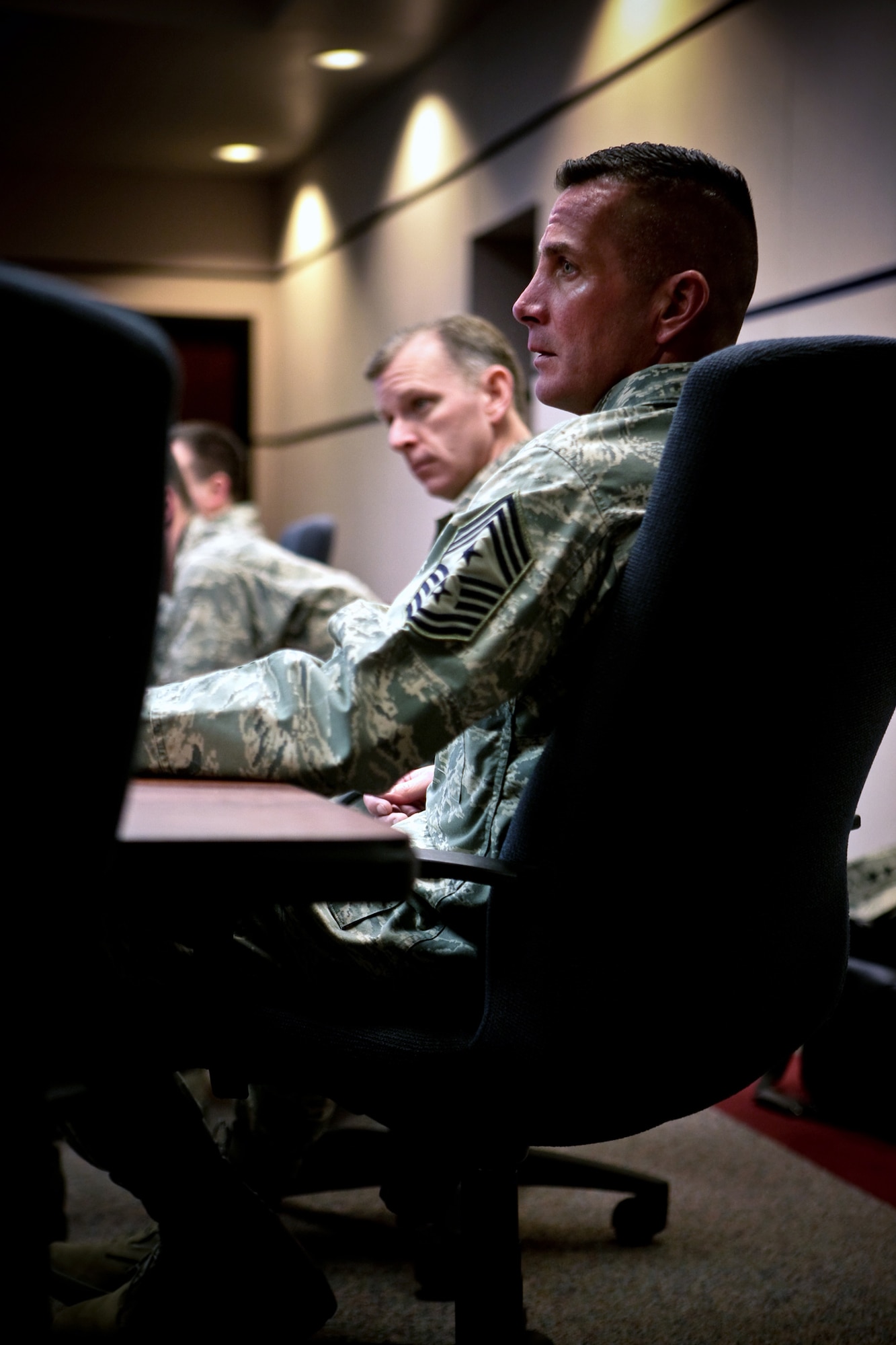Chief Master Sgt. Joseph Barron, Air Mobility Command command chief, and Chief Master Sgt. Jeffry Helm, U.S. Air Force Expeditionary Center command chief, listen in on a briefing at the Center on Fort Dix, N.J., Jan. 22.  Chief Barron was at the Center along with Gen. Arthur Lichte, AMC commander, for an official visit.  (U.S. Air Force Photo/Master Sgt. Bob Lorusso)