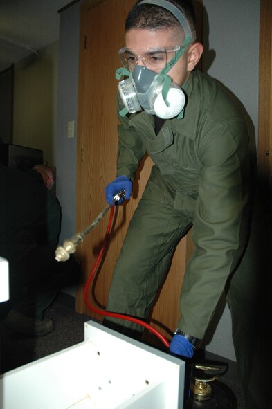 MINOT AIR FORCE BASE, N.D. -- Airman 1st Class Joel Mendoza, a pest management apprentice with the 5th Civil Engineering Squadron, prepares to spray an insect growth regulator in a dorm room here Jan. 25. The spray prevents target insects from maturing to adulthood, leaving them incapable of reproducing. (U.S. Air Force photo by Staff Sgt. Thomas Dow)