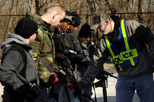 SCOTT AIR FORCE BASE, Ill. -- Tech. Sgt. Richard Reed, 375th Security Forces Squadron security forces trainer, shows fellow 375th Airlift Wing servicemembers who are playing the role of terrorists how to properly charge their weapons before a simulated attack on 375th Logistics Readiness Squadron members. (U.S. Air Force photo by Airman 1st Class Jonathan Lovelady)