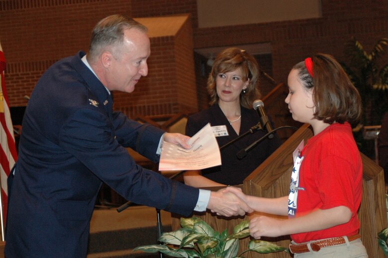 Col. Ed Walker, 917th Wing commander, shakes the hand of a graduate from Apollo Elementary, Bossier City, La., at STARBASE's 300th graduation ceremony held at Asbury Methodist Church, Bossier City, La., Friday, Jan. 25. (U.S. Air Force photo/Master Sgt. Sherri Bohannon)
