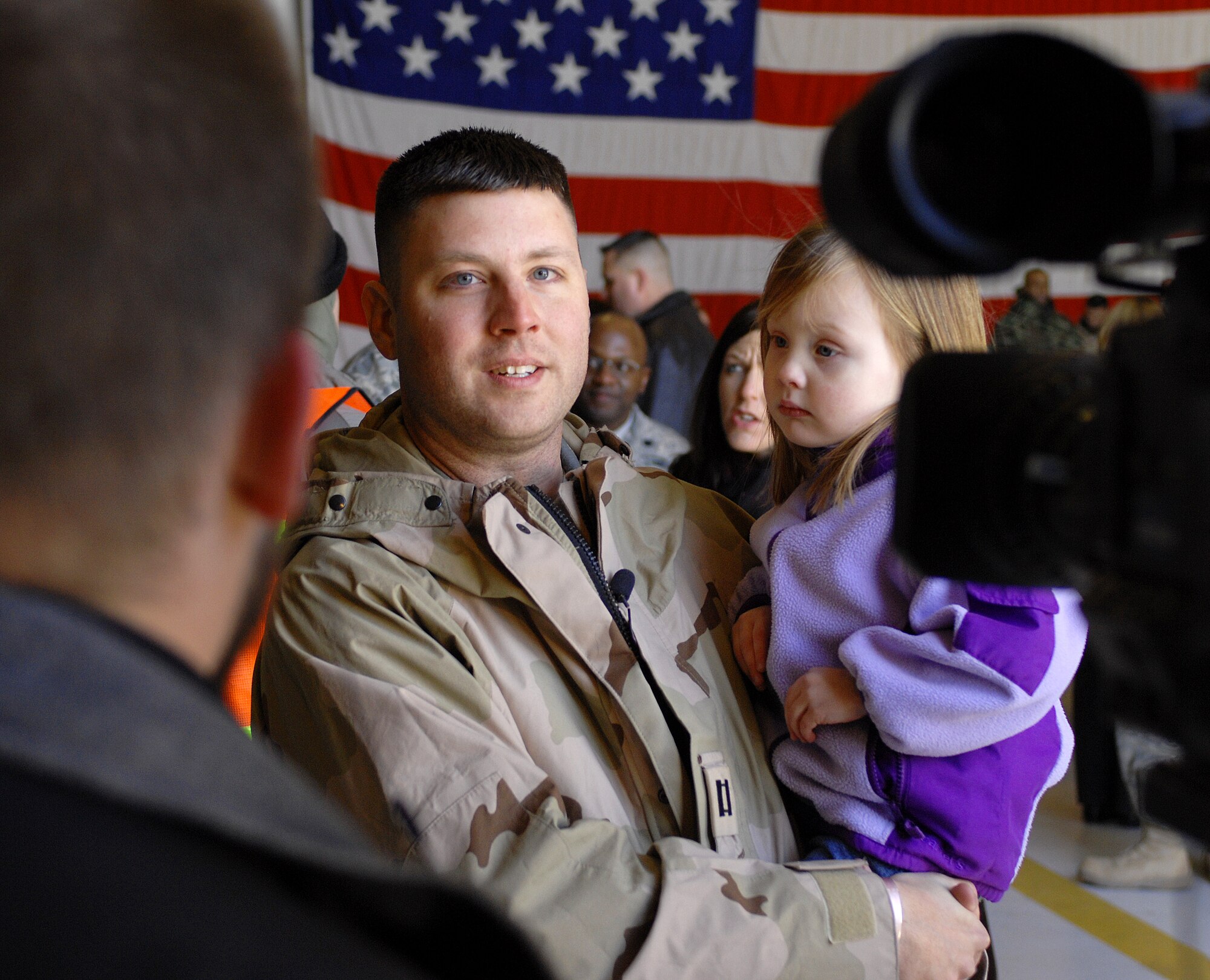 MOUNTAIN HOME AIR FORCE BASE, Idaho -- Capt. Caleb Martiny, 726th Air Control Squadron, and his daughter give an interview to local Channel 2 News about his recent deployment to Iraq. The Airmen served at different locations within Iraq since September 2007 in support of Operation Iraqi Freedom. While deployed, their mission was to monitor the airspace over the battlefield and provide military leaders with a clear and accurate “picture” of that area, allowing commanders to make informed, real-time decisions. (U.S. Air Force photo/ Airman 1st Class Ryan Crane)