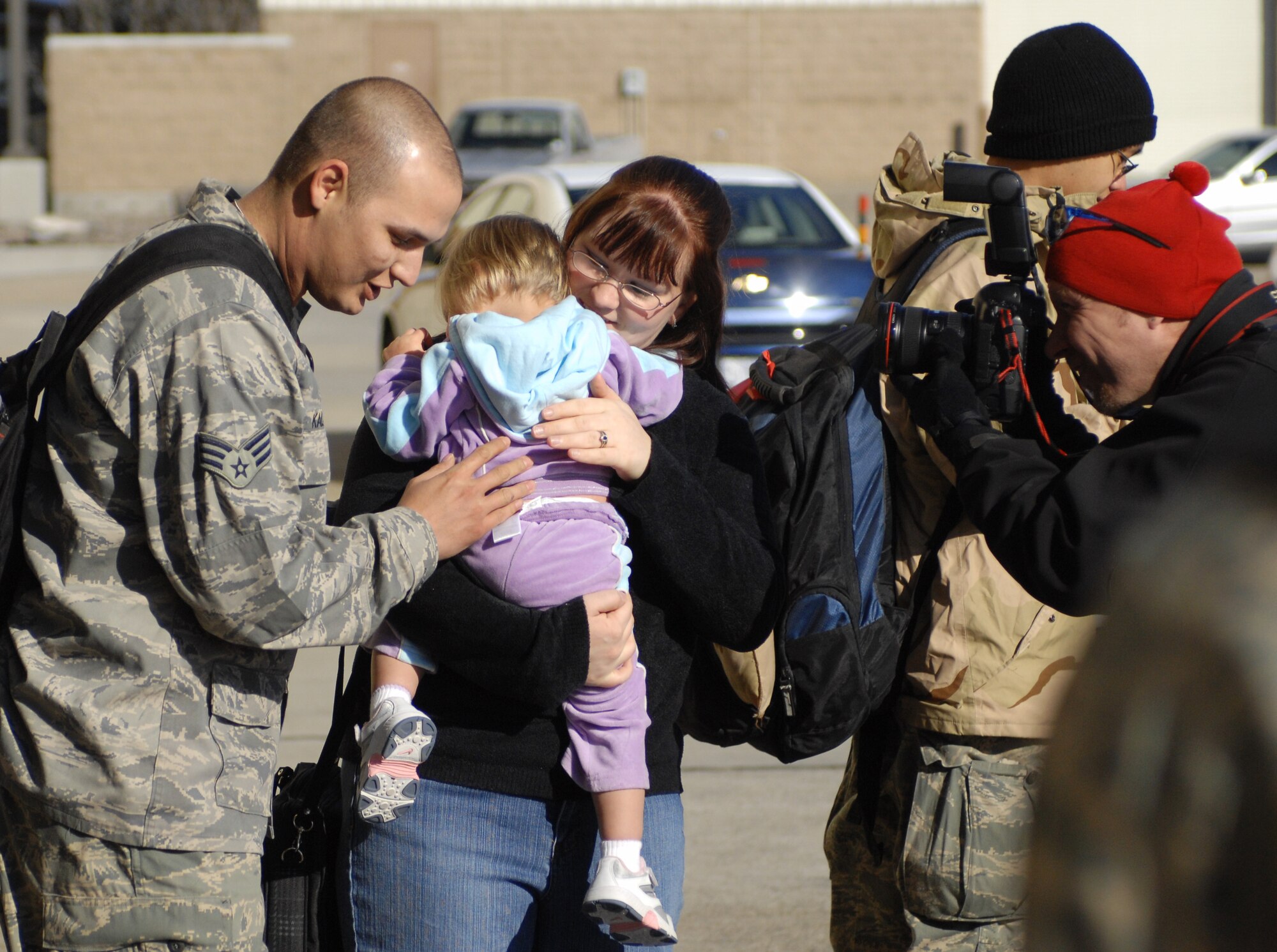 MOUNTAIN HOME AIR FORCE BASE, Idaho -- Senior Airman Erik Kalanquin, 726th Air Control Squadron, is greeted by his wife and daughter after over four months away from home, Jan 23. The Airmen served at different locations within Iraq since September 2007 in support of Operation Iraqi Freedom. While deployed, their mission was to monitor the airspace over the battlefield and provide military leaders with a clear and accurate “picture” of that area, allowing commanders to make informed, real-time decisions. (U.S. Air Force photo/ Airman 1st Class Ryan Crane)