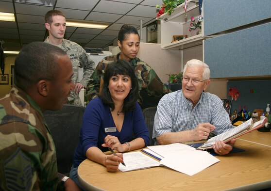 Bill Ward briefs exception to policy request cases he will turn over to his co-workers, (from left) Master Sgt. Cameron Jones, Tech. Sgt. Jeff Gilbert, Letty Inabinet and Tech. Sgt. Yahil Sanchez, prior to his retirement. (U.S. Air Force photo/Master Sgt. James Brabenec) 