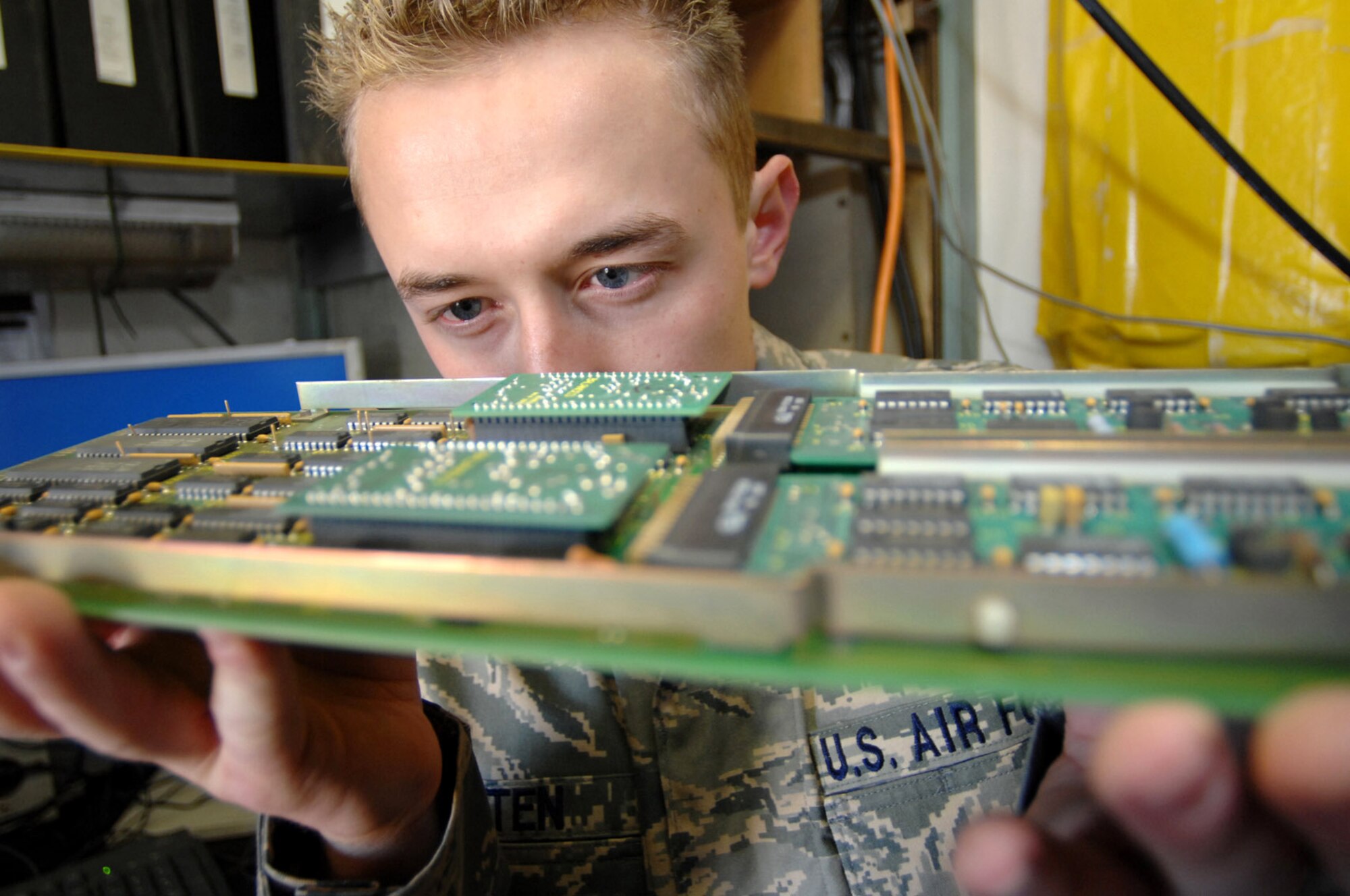 Senior Airman Zachary Felten examines minuscule circuits on one of the circuit cards from an FCC-100 multiplexer Jan. 22 at Balad Air Base, Iraq. Each card can receive upwards of 50 signals at any moment and send them to air traffic control scopes which projects an image of the air space. No job is too small for the communications Airmen who maintain the systems that monitor combat air space here. Airman Felten is a 727th Expeditionary Air Control Squadron tech controller deployed from Eglin Air Force Base, Fla. (U.S. Air Force photo/Senior Airman Julianne Showalter) 