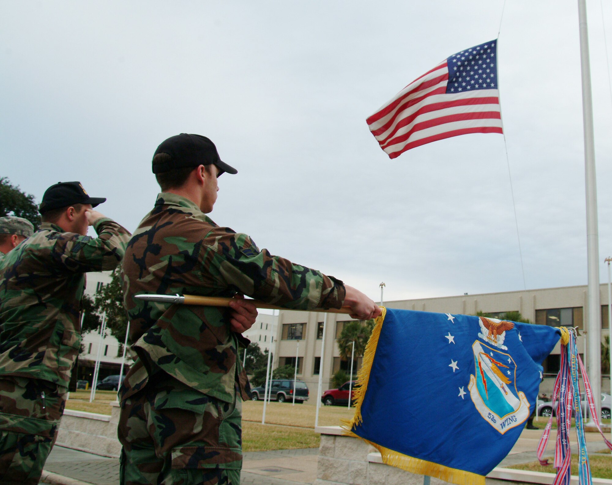 Airman 1st Class Robert Blackmon, 68th Electronic Warfare Squadron, presents the guidon while the base flag is lowered during the retreat ceremony held Jan. 24 at Eglin Air Force Base, Fla.  More than 135 53d Wing members participated in the ceremony. 