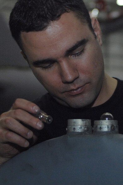 Senior Airman Tim Trujillo, 100th Maintenance Squadron crew chief, replaces an external bulb on a KC-135 here Dec. 10, 2007. (U.S. Air Force photo by Senior Airman Teresa M. Hawkins)