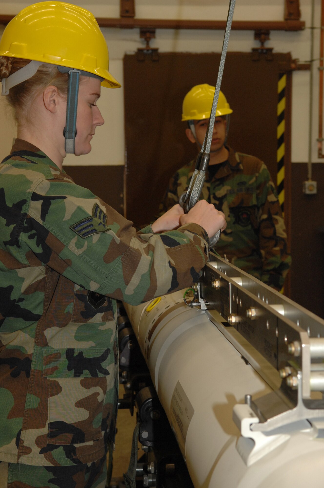 Senior Airman Jessica Seale, 435th Munitions Squadron, connects a sling to the Air-to-Ground Missile-88 High-speed Anti-Radiation Missile in preparation to lifting the missile from the maintenance stand  Jan. 23 at  Ramstein Air Base.  The AGM-88 HARM is now going to be inspected every five years instead of ten.  The missiles are old and have a higher failure rate.  (U.S. Air Force photo/ Airman 1st Class Amber Bressler)(RELEASED)