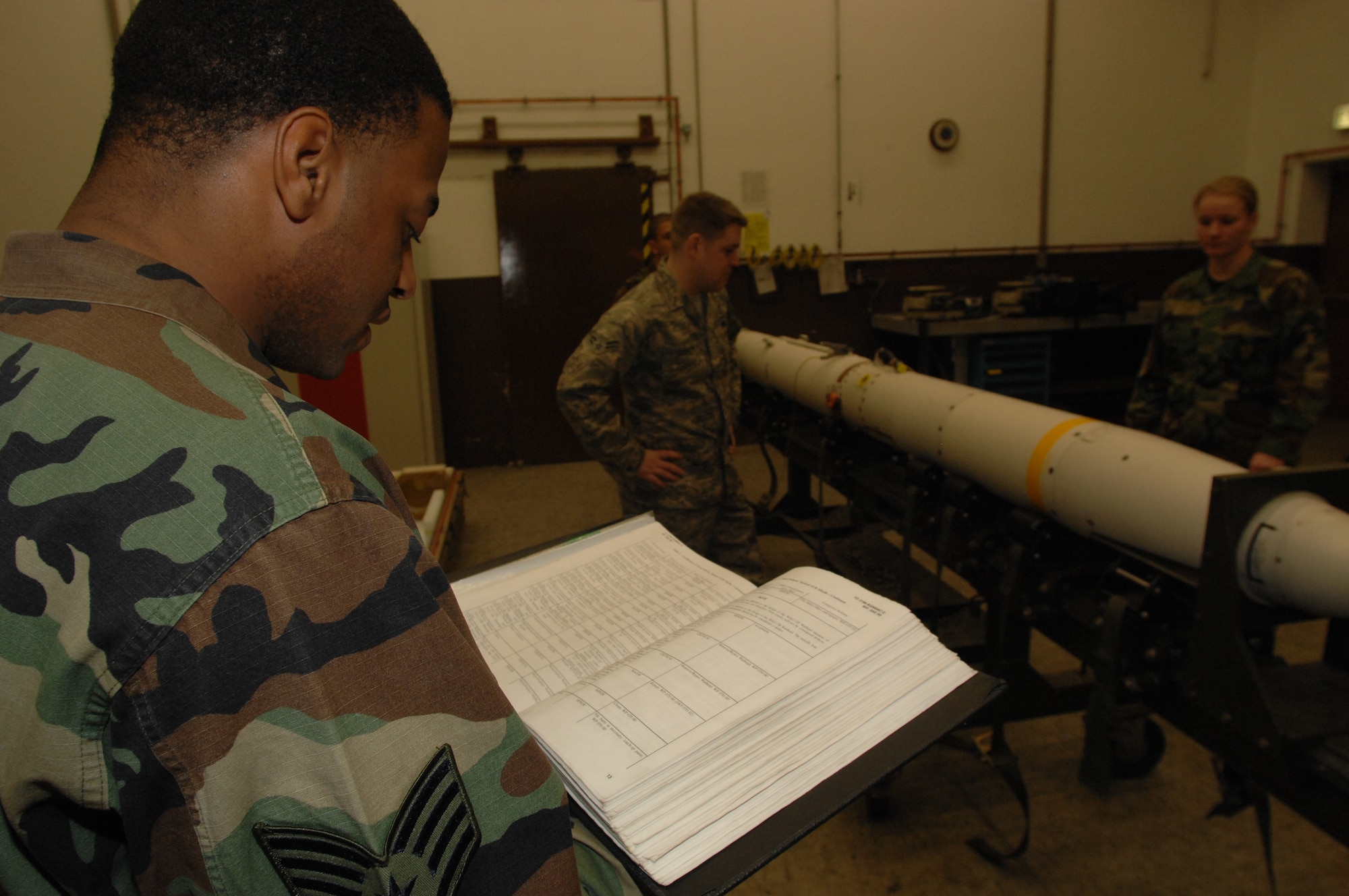 Staff Sgt. Maurice Jones, 435th Munitions Squadron, reads the visual inspection steps for Air-to-Ground Missile-88 High-speed Anti-Radiation Missile from the Item Technical order checklist Jan. 23 at Ramstein Air Base.  The AGM-88 HARM is now going to be inspected every five years instead of ten.  The missiles are old and have a higher failure rate.  (U.S. Air Force photo/ Airman 1st Class Amber Bressler)(RELEASED)