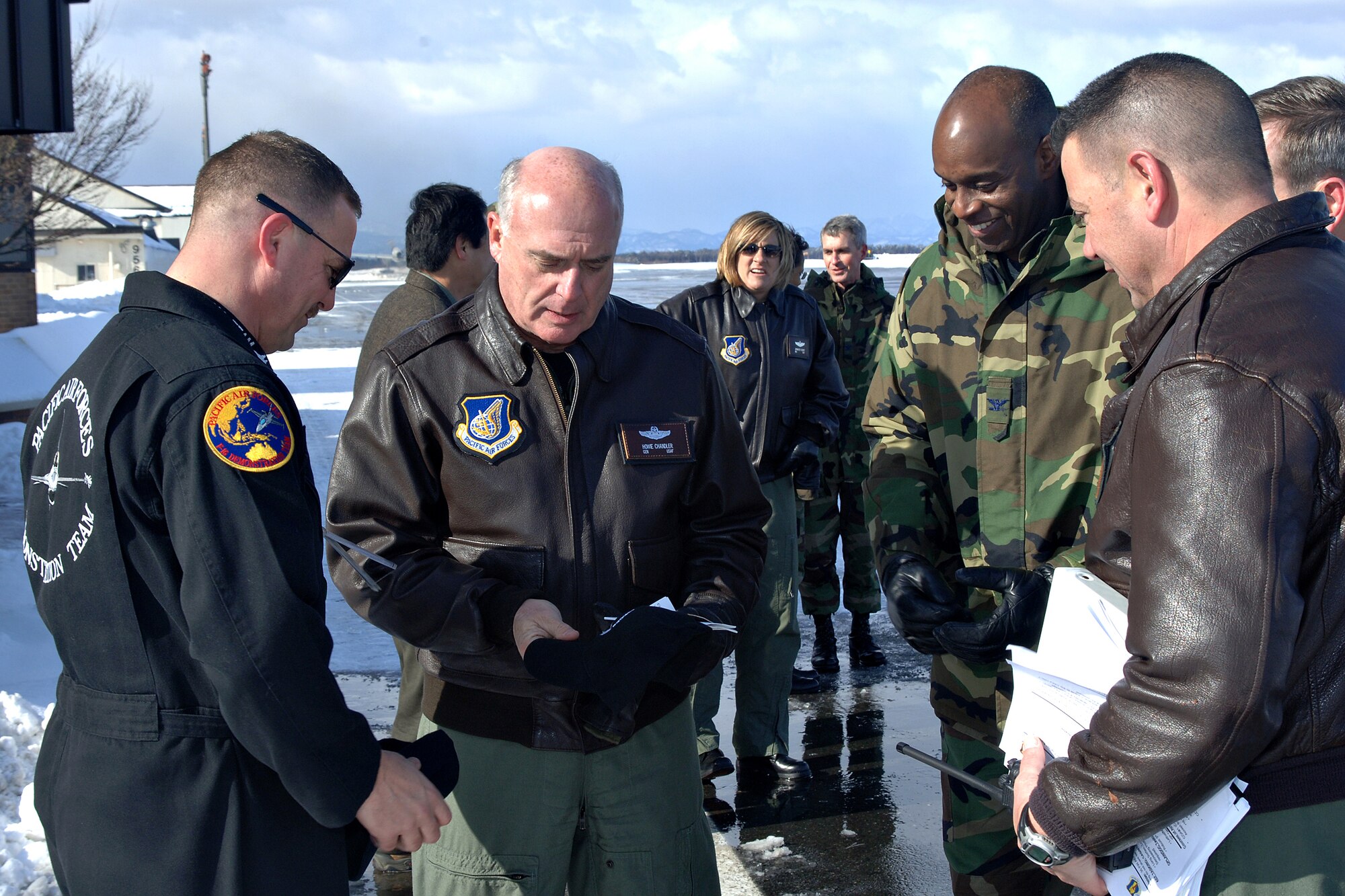 MISAWA AIR BASE, Japan -- Master Sgt. Richard Robinson (left), 35th Aircraft Maintenance Squadron, presents a Pacific Air Forces Demonstration Team hat to Gen. Howie Chandler (center), PACAF commander, here Jan. 25, 2008.  General Chandler was treated to a demonstration by the team during his first official visit to Misawa, where the demo team is based out of.  (U.S. Air Force photo by Airman 1st Class Benjamin Wilson)