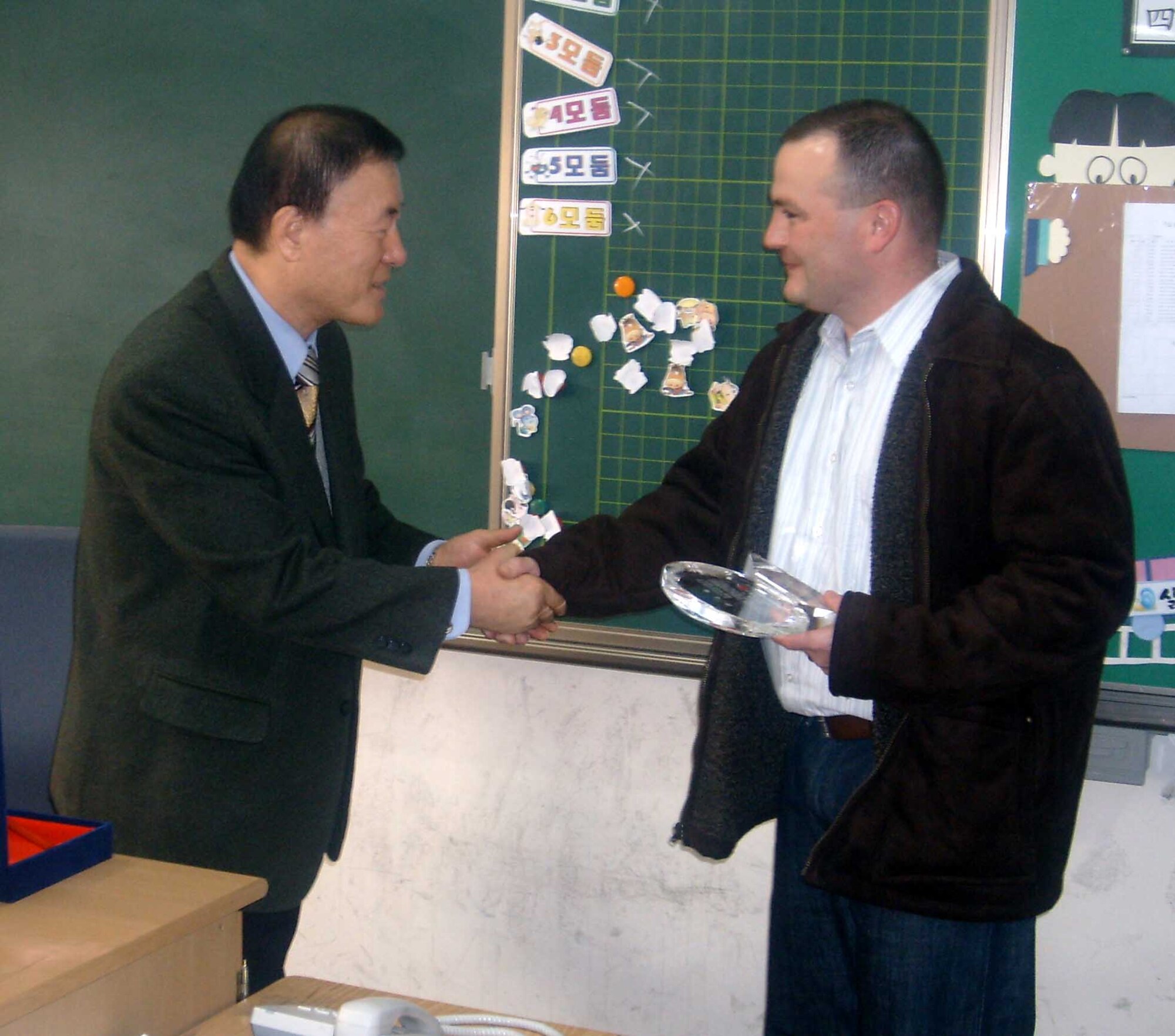 GWANGJU AIR BASE, Republic of Korea  -- Master Sgt. Darin Reed, (right), receives a Plaque of Appreciation from Mr. Cheon Kyu Park, Do-San Elementary School principal. Airmen from the 607th Material Maintenance Squadron, Detachment 1, have been teaching English to students every other Saturday since October 2006.