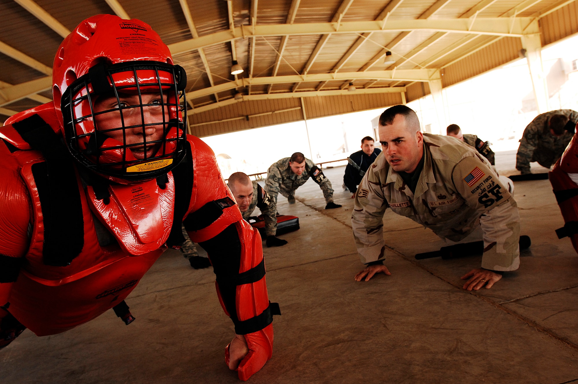 SOUTHWEST ASIA -- Airmen do pushups for a mistake made Jan. 24, 2008, during self defense tactics training with batons at an air base in the Persian Gulf Region. The self defense training familiarizes Airmen with how to use non-lethal force to defend themselves. The Airmen are assigned to the 386th Expeditionary Security Forces Squadron and are deployed in support of Operation Iraqi Freedom. (U.S. Air Force photo/ Senior Airman Patrick Dixon)