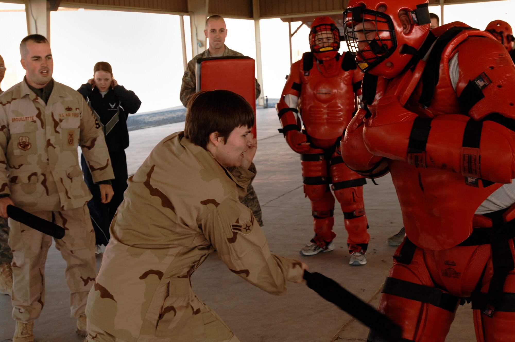 SOUTHWEST ASIA -- Airman 1st Class Amber Morton strikes Airman 1st Class Tyler Brunner, in the red protective suit, Jan. 24, 2008, during self defense tactics training with batons at an air base in the Persian Gulf Region. The self defense training familiarizes Airmen with how to use non-lethal force to defend themselves. Airman Morton and Brunner are assigned to the 386th Expeditionary Security Forces Squadron and are deployed in support of Operation Iraqi Freedom. (U.S. Air Force photo/ Senior Airman Patrick Dixon)