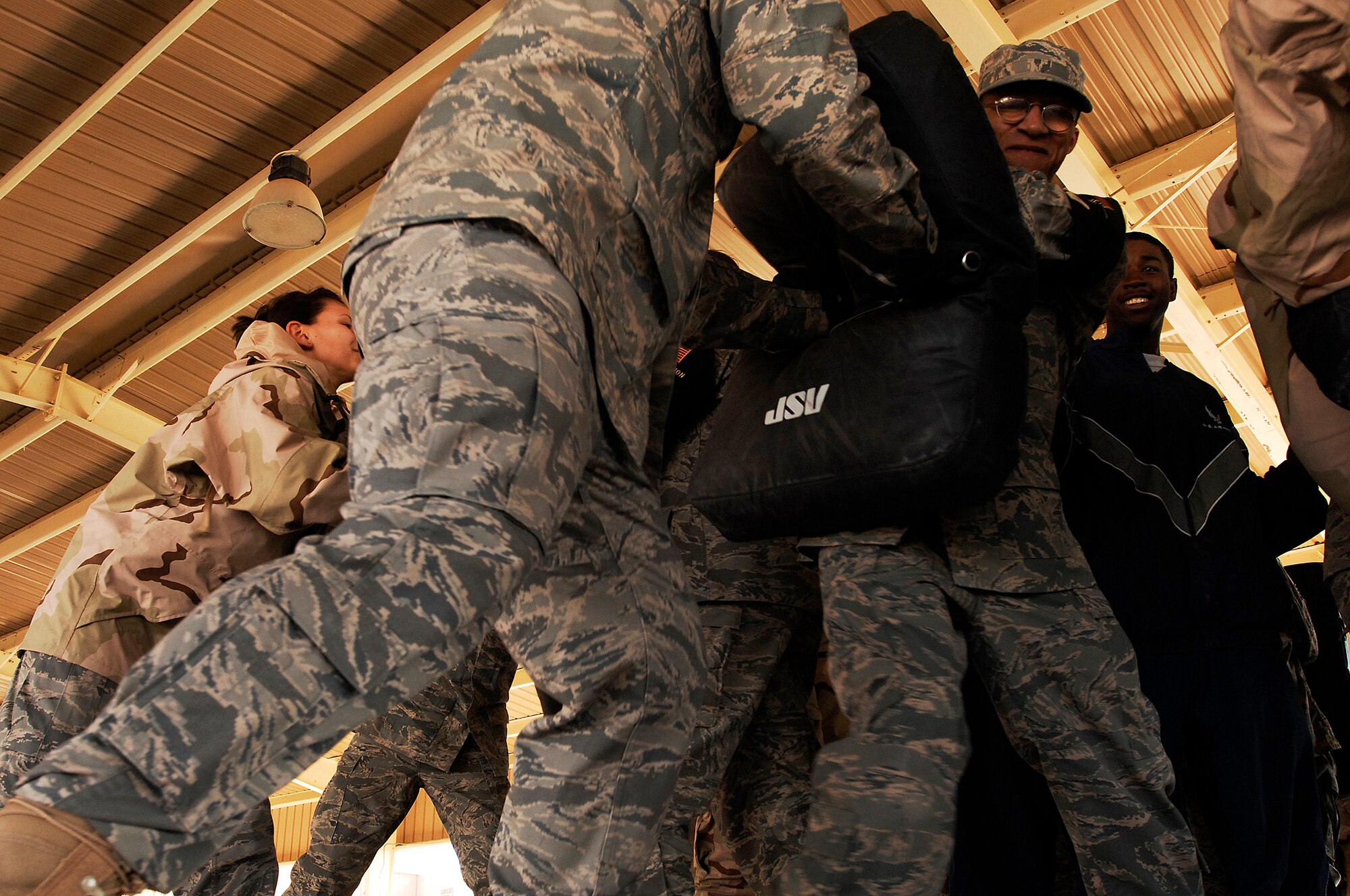 SOUTHWEST ASIA -- Staff Sgt. Mack Williams grimaces while holding a striking pad Jan. 24, 2008, during self defense tactics training with batons at an air base in the Persian Gulf Region. The self defense training familiarizes Airmen with how to use non-lethal force to defend themselves. Sergeant Williams is assigned to the 386th Expeditionary Security Forces Squadron and is deployed in support of Operation Iraqi Freedom. (U.S. Air Force photo/ Senior Airman Patrick Dixon)