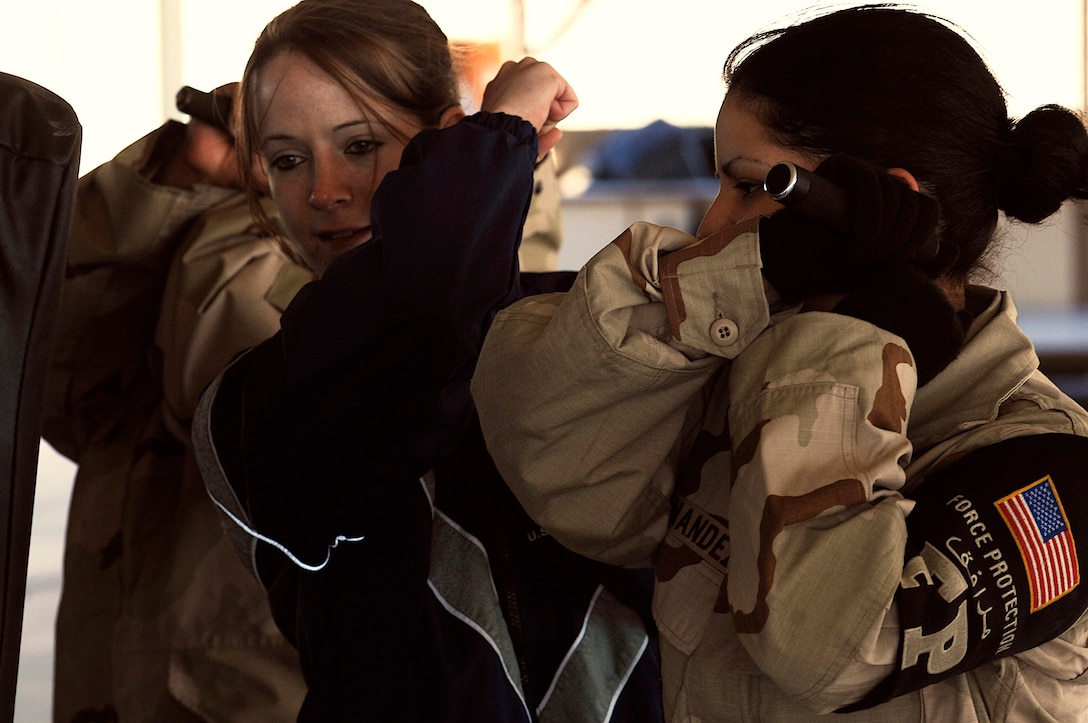 SOUTHWEST ASIA -- Airman 1st Class Amber Motske (left) instructs Senior Airman Cassandra Hernandez on how to strike using her baton Jan. 24, 2008, during self defense tactics training with batons at an air base in the Persian Gulf Region. The self defense training familiarizes Airmen with how to use non-lethal force to defend themselves. Both Airmen are assigned to the 386th Expeditionary Security Forces Squadron and are deployed in support of Operation Iraqi Freedom. (U.S. Air Force photo/ Senior Airman Patrick Dixon)