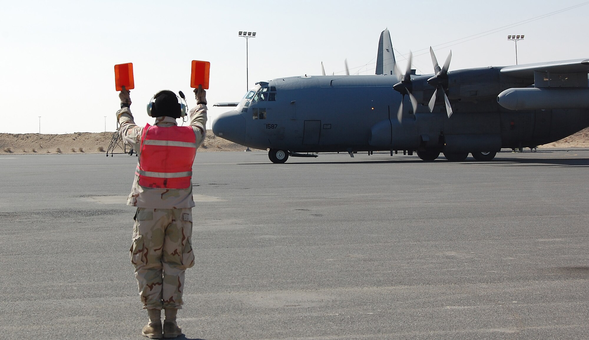 SOUTHWEST ASIA -- Staff Sgt. Jeffrey Weeks, an aerospace maintenance technician with the 386th Expeditionary Aircraft Maintenance Squadron, marshals an EC-130H Compass Call on a flightline in the Persian Gulf region. The EC-130H Compass Call system employs offensive counter-information and electronic attack capabilities supporting U.S. and Coalition tactical air, surface, and special operations forces. Sergeant Weeks is deployed from the 755th AMXS at Davis-Monthan Air Force Base, Ariz. , in support of Operations Enduring and Iraqi Freedom. (U.S. Air Force photo/Capt Jason L. McCree) 