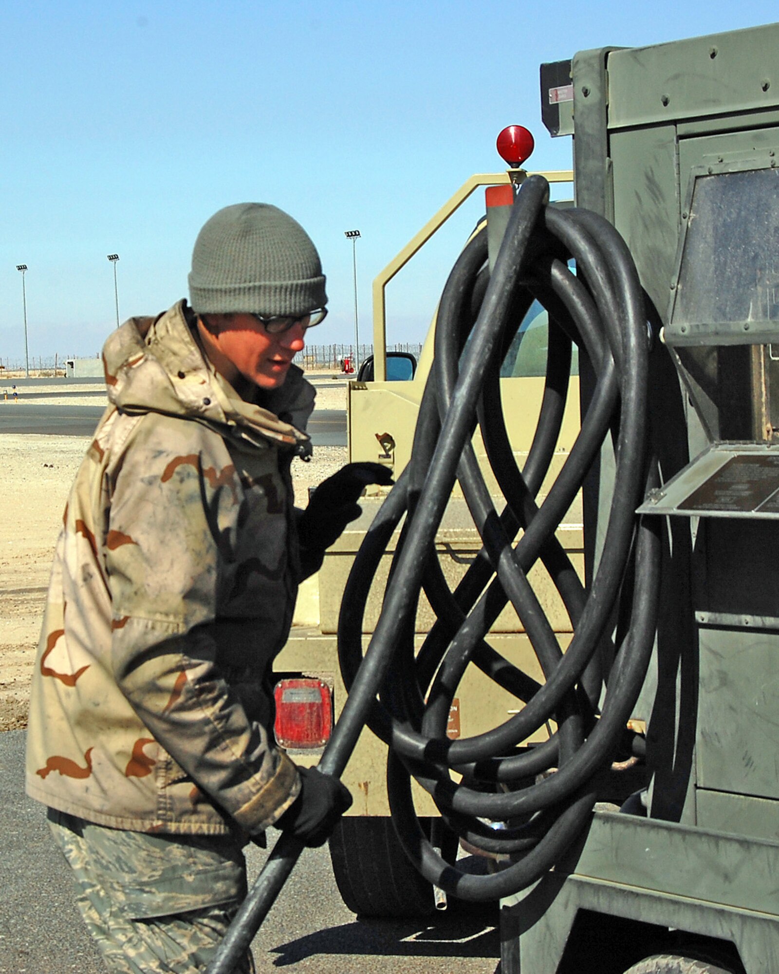 SOUTHWEST ASIA -- Senior Airman Steven Oliver, an aerospace propulsion specialist, wraps a power cord after an EC-130H Compass Call engine start Jan. 24 on a flightline in the Persian Gulf region. The Compass Call system employs offensive counter-information and electronic attack capabilities supporting U.S. and coalition tactical air, surface, and special operations forces. Airman Oliver is deployed from the 755th AMXS at Davis-Monthan Air Force Base, Ariz., in support of Operations Enduring and Iraqi Freedom (U.S. Air Force photo/Capt. Jason McCree)