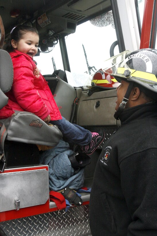 A little girl sits in a fire truck Jan. 26 as Terry Cruse, a driver with the Jacksonville Fire Department, talks to her about being a fireman during a ?support the troops? rally here. The Jacksonville Fire Department came to the rally to show support for the deployed troops.