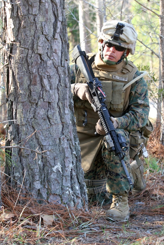 Pfc. Jose Alfredo Martinez Rodriguez of Company F, 2nd Battalion, 2nd Marine Regiment, 2nd Marine Division, II Marine Expeditionary Force, takes cover behind a tree during a training scenario at the Military Operations in Urban Terrain facility here Jan. 28. This exercise is one of many during their Battalion Field Exercise preparing these Marines for an upcoming deployment to Iraq. (Official U.S. Marine Corps photo by Lance Cpl. Joshua Murray) (RELEASED)