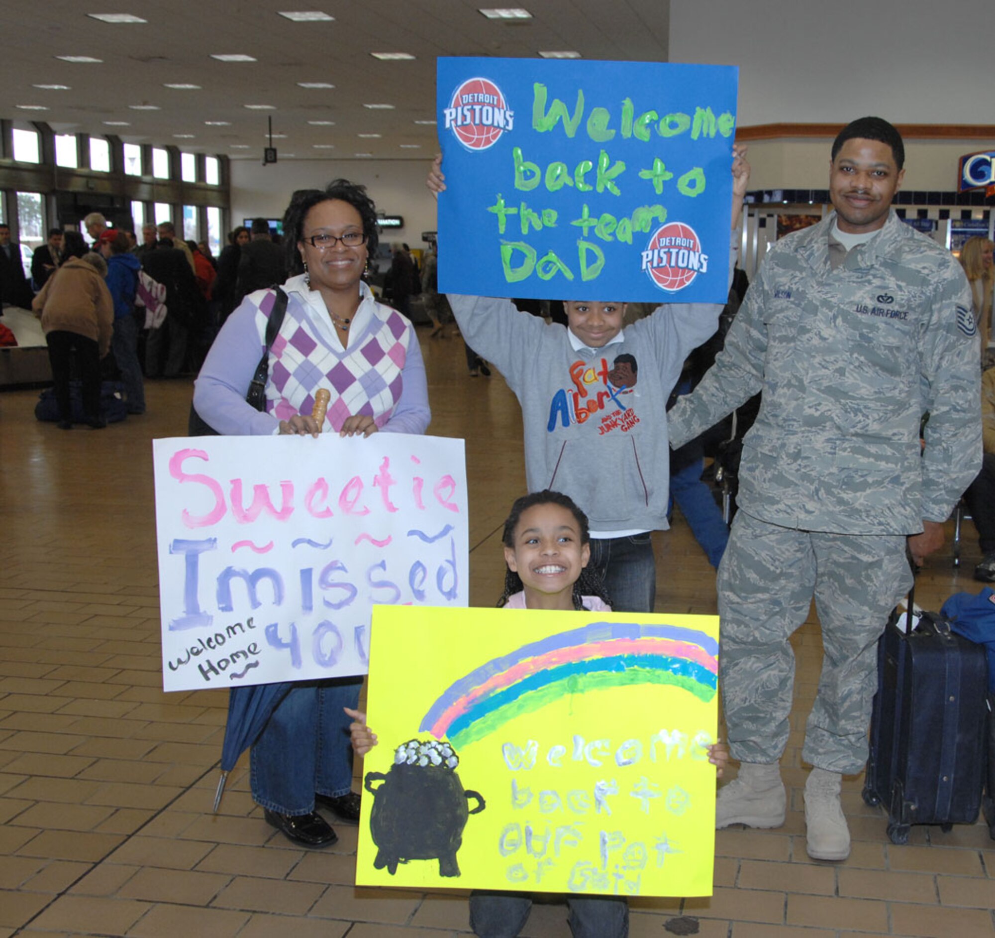 TRAVIS AIR FORCE BASE, Calif. -- All smiles: Technical Sgt. Chavares Wilson, a heating and air conditioning technician with the 349th Civil Engineer Squadron, Travis Air Force Base, gets an enthusiastic “welcome back” from his family, who were waiting for him after he got off the plane at Sacramento International Airport, January 24. Sergeant Wilson, along with nine other members from his unit, was returning from a four-month deployment at Kirkuk Air Base, Iraq. There, Sergeant Wilson along with the other members from his squadron built and maintained the vital structures and services that kept the base provided with such amenities as heating and air conditioning, a reliable source of electricity, plumbing, tents and other required structures. (U.S. Air Force photo/Master Sgt. Wendy Weidenhamer.)